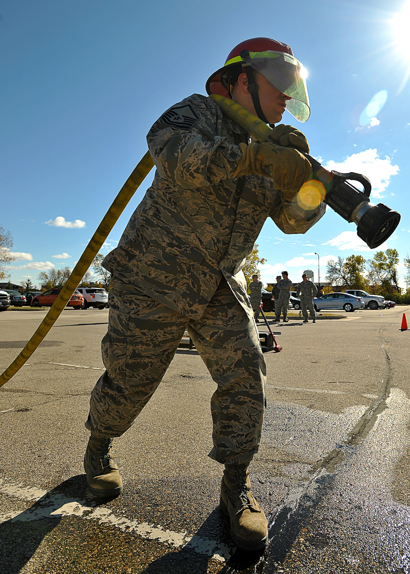With the sun shining down on him, Master Sgt. Daniel Shannon, 319th Air Base Wing Flight Safety superintendent, gets into position as he anticipates the start of the timed fireman team challenge to start on Oct. 9, 2014, on Grand Forks Air Force Base, N.D. Shannon had the overall best time with one minute and six seconds out of ten participants. (U.S. Air Force photo/Senior Airman Xavier Navarro)