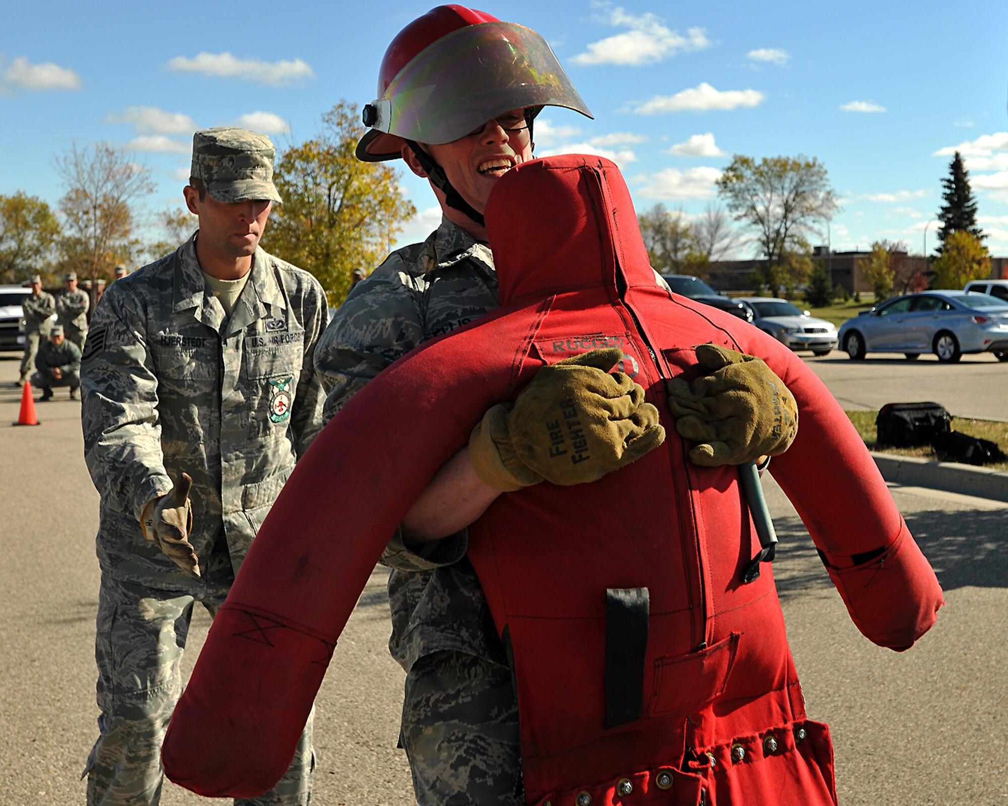 Grand Forks Air Force Base Fireman, Staff Sgt. Stephen Hjersted provides fall protection while 1st Lt. Grant Ellis, 319th Logistics Readiness Squadron director of operations, drags a dummy during a timed fireman team challenge course on Oct. 9, 2014, on Grand Forks Air Force Base, N.D.  The dummy weighed more than 130 pounds. The 319th LRS team placed second in the challenge by finishing the course with a time of two minutes and 52 seconds. (U.S. Air Force photo/Senior Airman Xavier Navarro)