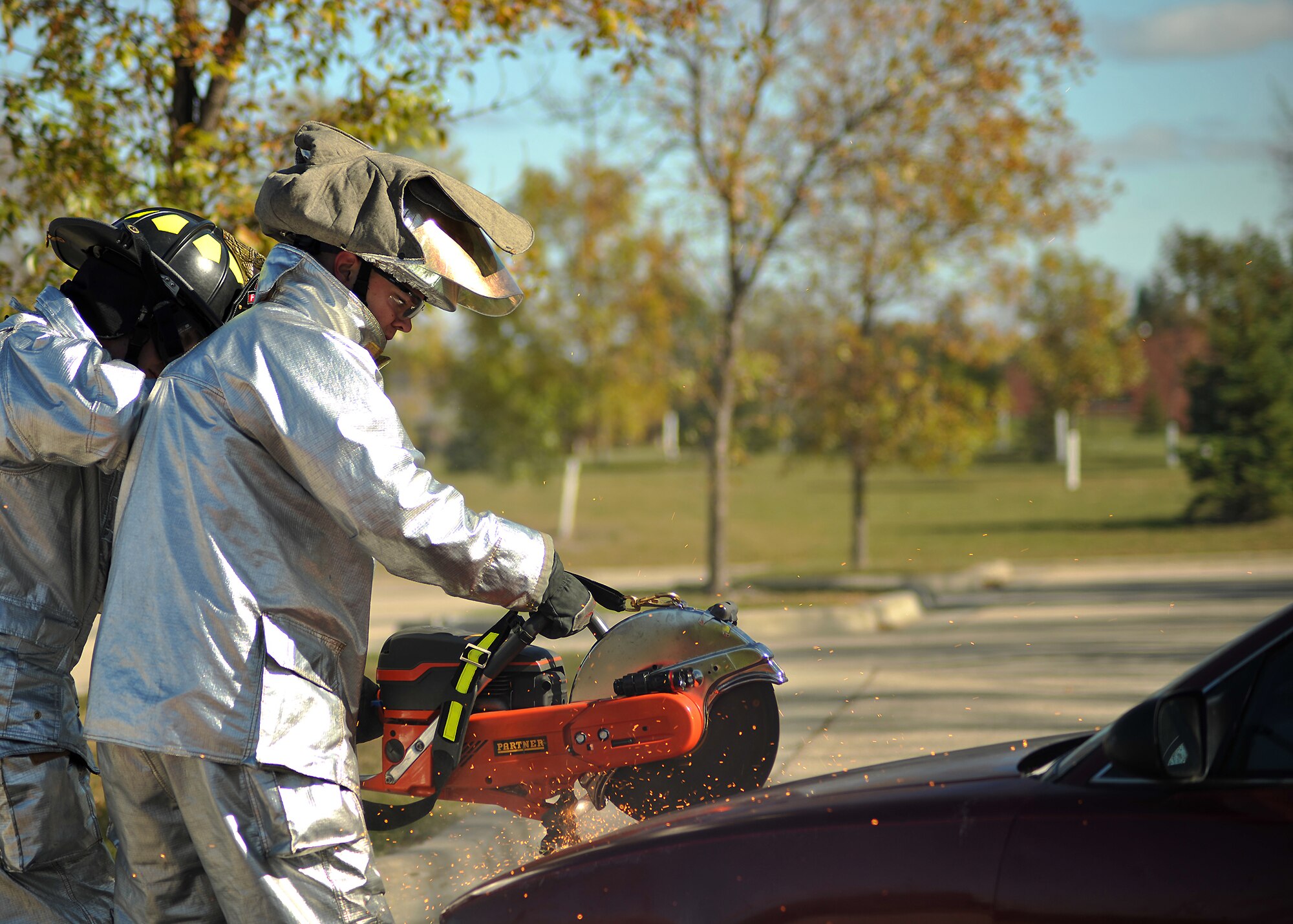 Airman 1st Class Brian Pierson, 319th Civil Engineer Squadron, uses a K-12 FD Fire/Rescue Saw to cut into the front hood of a car during an extraction demonstration on Oct. 9, 2014, on Grand Forks Air Force Base, N.D. The car extraction showed different tools and techniques that firemen use to safely and quickly remove a victim from the vehicle of an accident. (U.S. Air Force photo/Senior Airman Xavier Navarro)