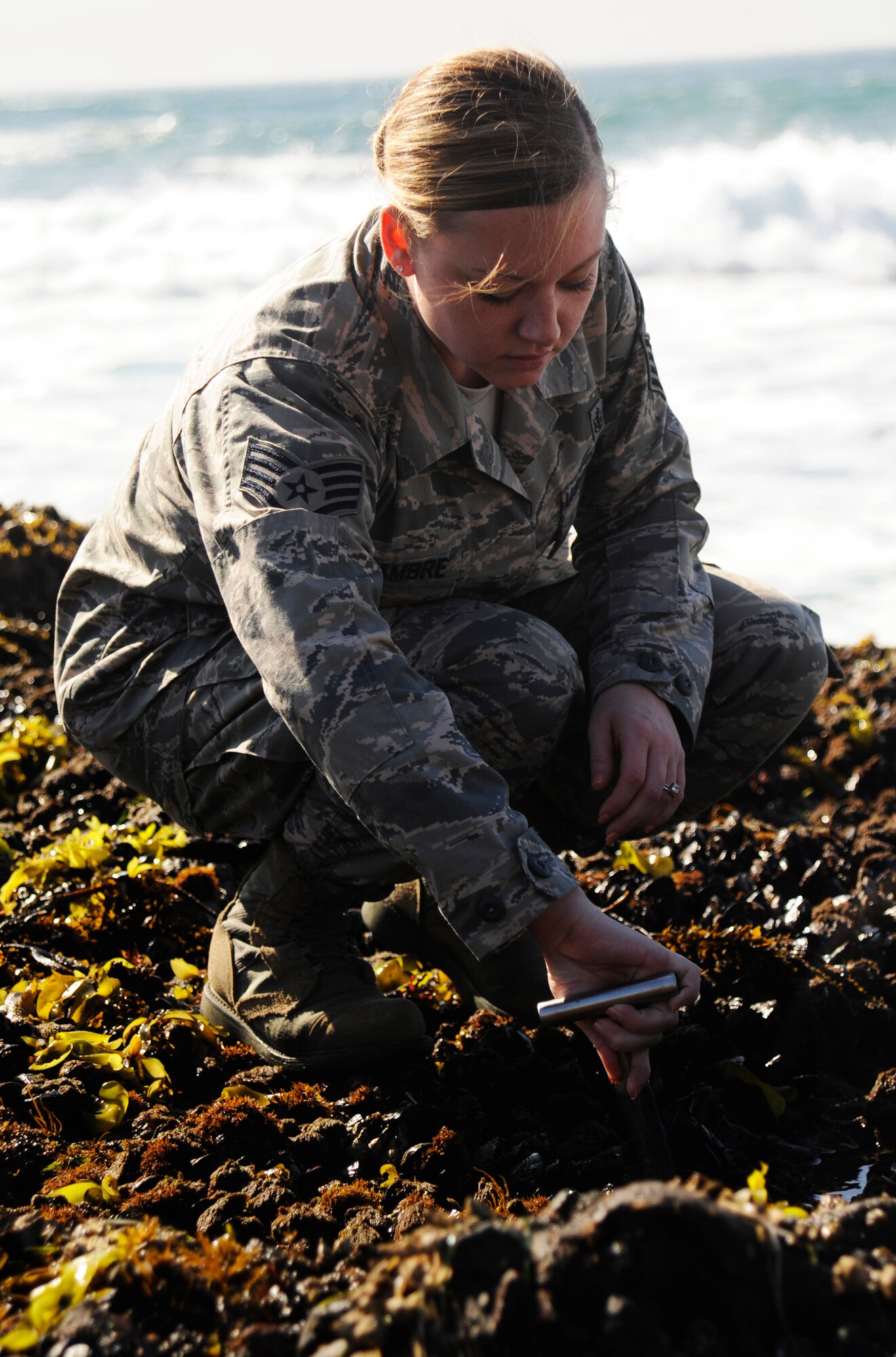 Staff Sgt. Ashley Delcambre, 30th Medical Operations Squadron public health technician, collects mussels for testing, Oct. 7, 2014, Vandenberg Air Force Base, Calif. Every month the 30th MDOS sends Airmen to collect mussels for testing, as part of the California Department of Public Health mussel watch program. (U.S. Air Force photo by Airman 1st Class Ian Dudley/Released)