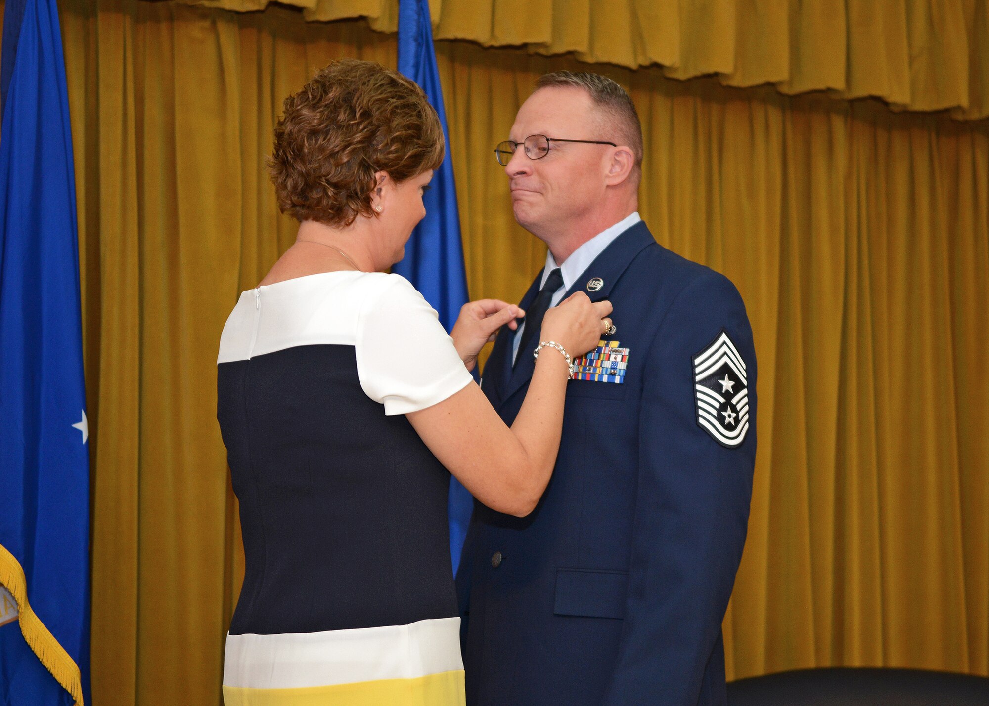 Kelly Randolph pins a retirement pin on Chief Master Sgt. Brian Randolph during his retirement ceremony Oct.15 at Club Muroc. (U.S. Air Force photo by Jet Fabara)