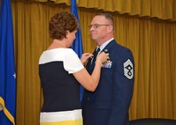 Kelly Randolph pins a retirement pin on Chief Master Sgt. Brian Randolph during his retirement ceremony Oct.15 at Club Muroc. (U.S. Air Force photo by Jet Fabara)
