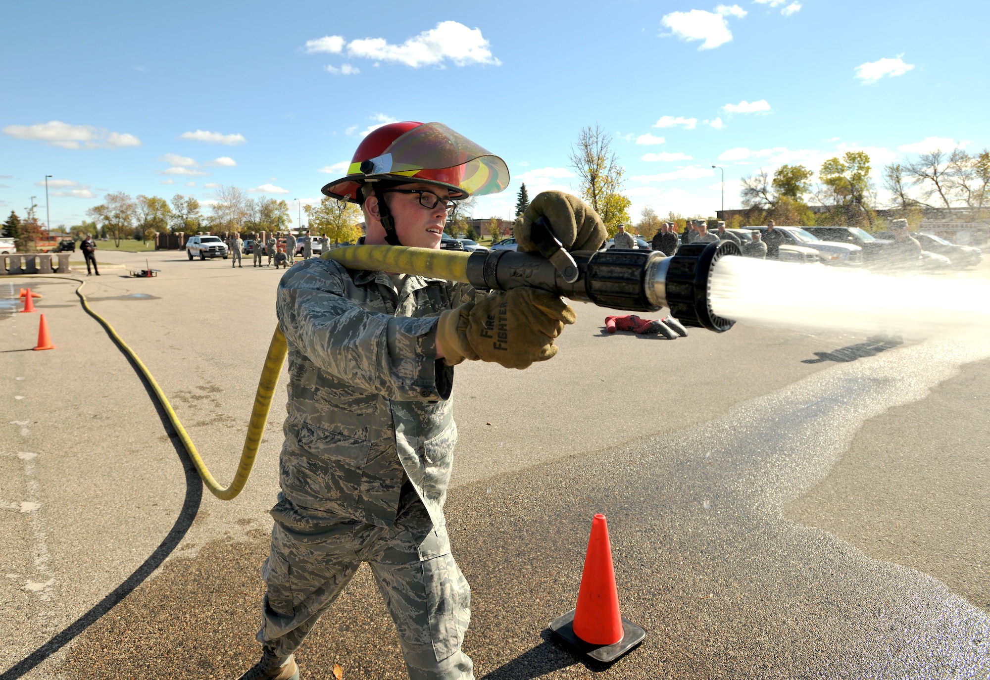1st Lt. Grant Ellis, 319th Logistics Readiness Squadron director of operations, concentrates on hitting a target with a pressured hose during a timed fireman team challenge on Oct. 9, 2014, on Grand Forks Air Force Base, N.D.  Ellis was one out of ten participants and finished the course with a time of one minute and 27 seconds. The 2014 Fireman Challenge was one of several events sponsored by the Grand Forks AFB Fire Department in observance of National Fire Prevention Week. (U.S. Air Force photo/Senior Airman Xavier Navarro)