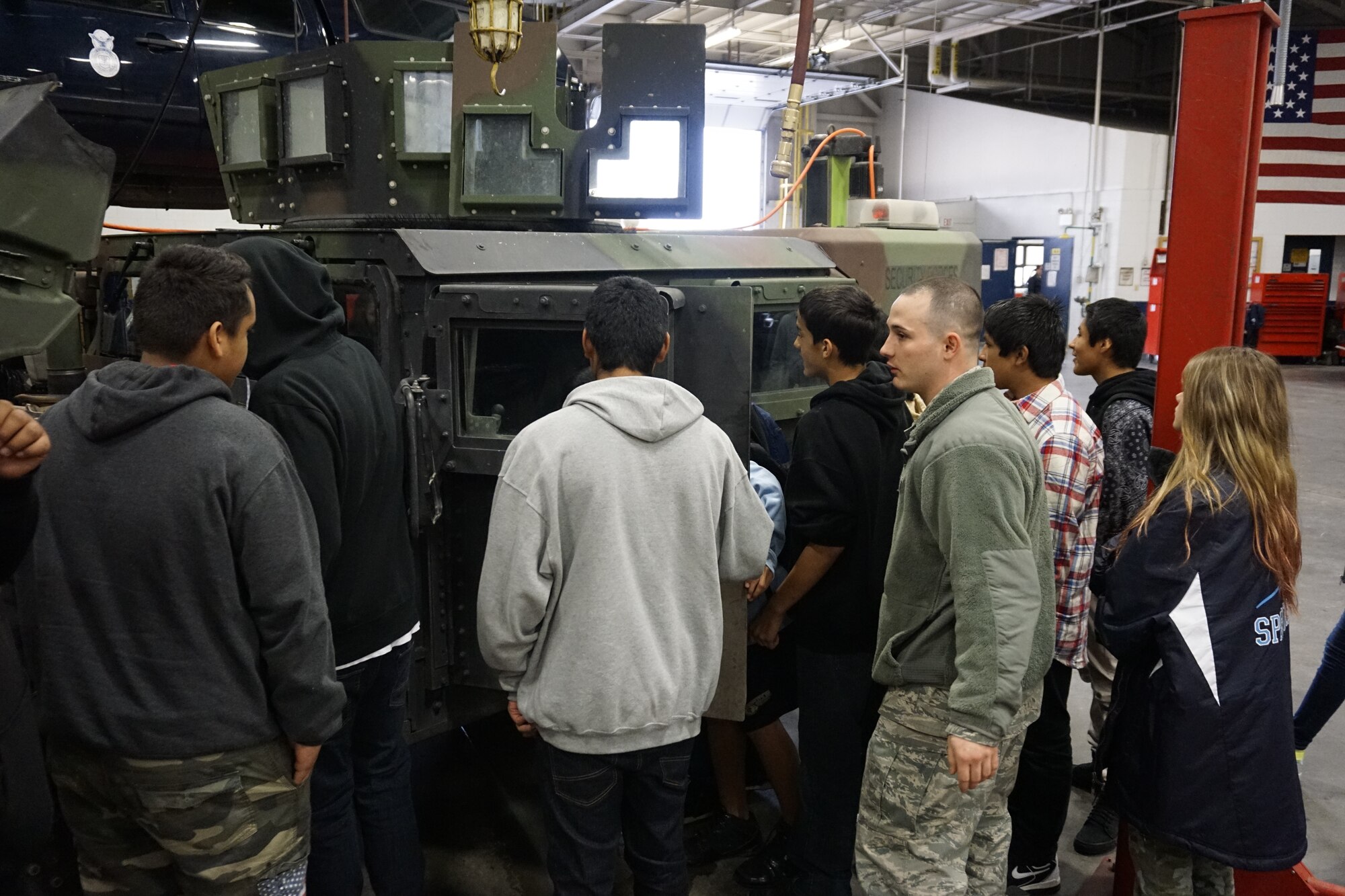 Senior Airman Colton Marichalar, 90th Logistics Readiness Squadron, describes the functions and capabilities of a 90th Security Forces Group HMMVV to Greeley-Evans School District 6, Colo., high school students in an LRS vehicle maintenance bay on F.E. Warren Air Force Base, Wyo., Sept. 10, 2015. The students toured the base to become familiarized with different operations and jobs the Air Force has to offer. (U.S. Air Force photo by Lan Kim)