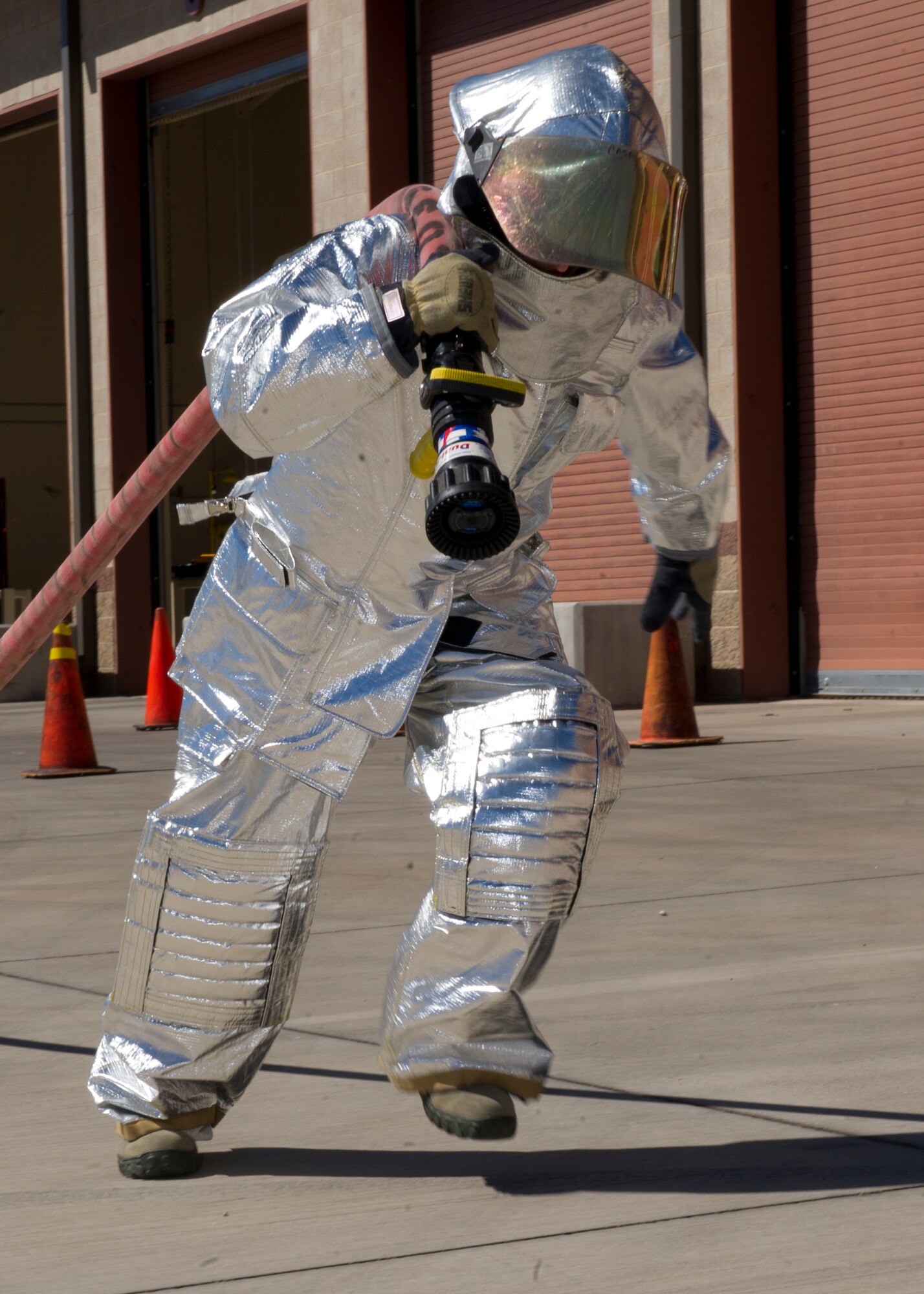 A member of the 49th Civil Engineer Squadron participates in the 100-foot hose pull event at the 2nd Annual Fire Fighter Challenge at Holloman Air Force Base, N.M. Oct. 10. The purpose of the firefighter challenge is to let the general public have a chance to try the everyday tasks that firefighters have to encounter. Some of the other events held at the challenge included a stair climb with a hotel pack, a 45-pound hose roll pull, the force sled also known as the Kiser sled, a serpentine run, and a 100-foot dummy drag. (U.S. Air Force photo by Staff Sgt. E’Lysia Wray/Released)