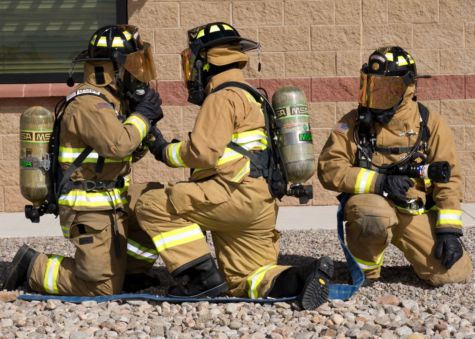 Firefighters assigned to Holloman Ladder 18 pre-check their breathing apparatuses as they demonstrate a response to a fire emergency at Holloman Air Force Base, N.M. Oct. 7. As part fire rescue training, crew members must respond and comply with hundreds of fire safety protocols during every emergency. They also have to test their knowledge of procedures and test their physical fitness to ensure they are ready to respond to any emergency. (U.S. Air Force photo by Staff Sgt. E’Lysia Wray/Released)