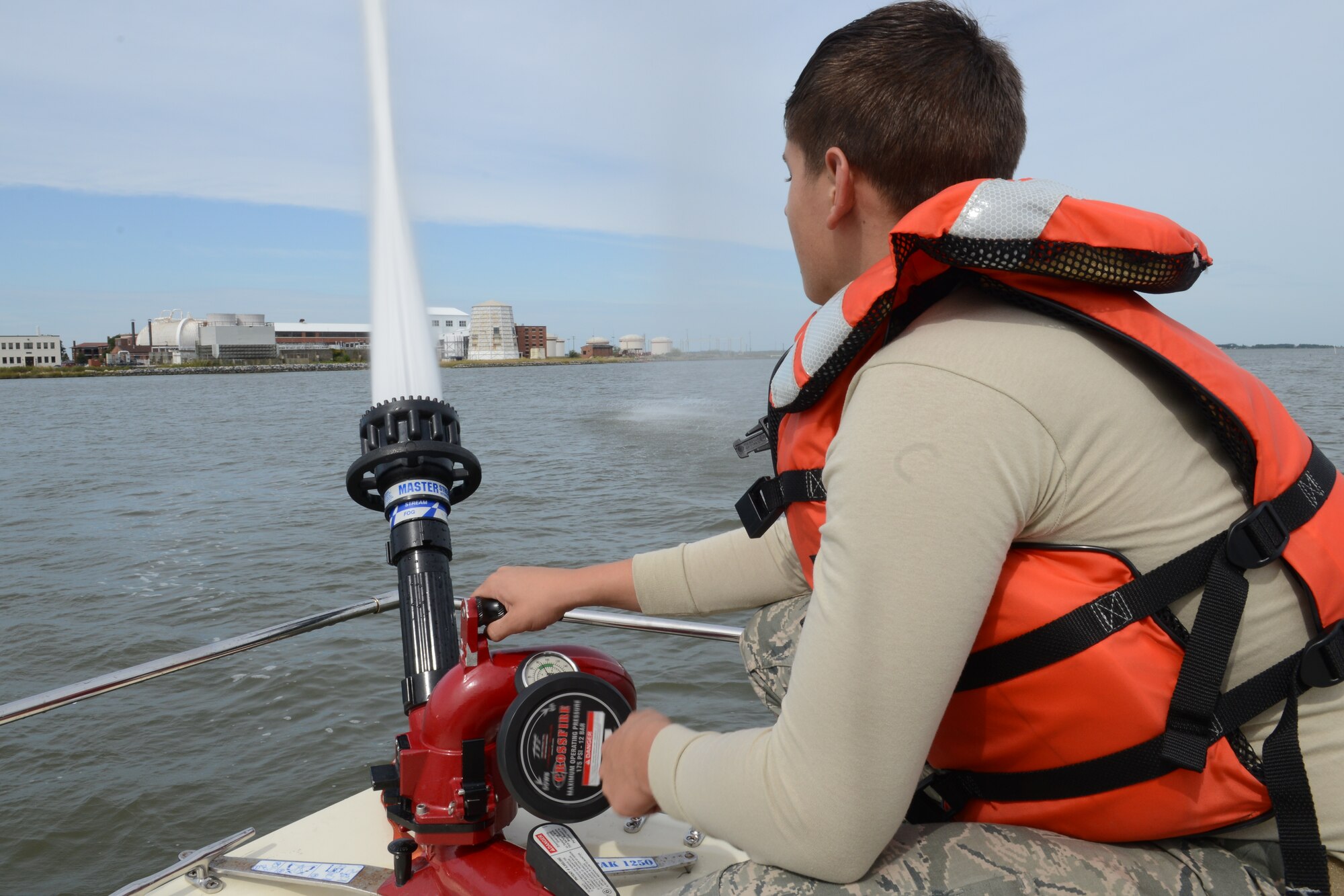 U.S. Air Force Airman 1st Class Scott Kolar, 633rd Civil Engineer Squadron firefighter, practices operating the water pump on the Langley Fire Rescue boat in Southwest Branch Back River near Langley Air Force Base, Va., Oct. 7, 2014. The pump sprays 500 gallons of water per minute and is used to extinguish shoreline fires. (U.S. Air Force photo by Airman 1st Class Devin Scott Michaels/Released)