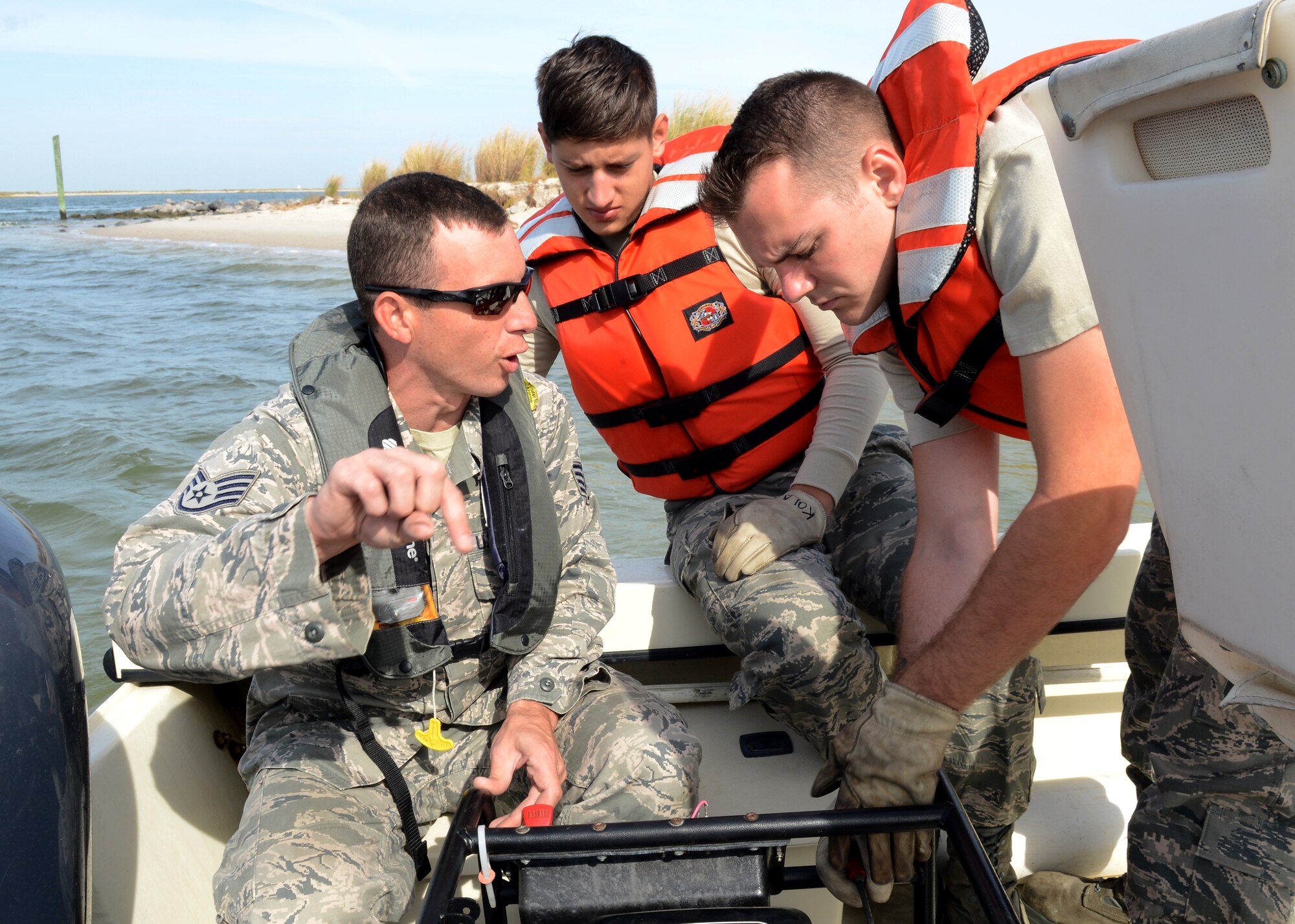 U.S. Air Force Staff Sgt. Robert Sapp, 633rd Civil Engineer Squadron fire rescue crew chief, teaches Airman 1st Class Scott Kolar and Senior Airman Alexander Scales, 633rd Civil Engineer Squadron fire fighters, how to start the water pump on the Langley Fire Rescue boat in Southwest Branch Back River near Langley Air Force Base, Va., Oct. 7, 2014. The pump’s engine pulls water from outside the boat and pushes it out of the water cannon at the front of the boat when combatting shoreline fires. (U.S. Air Force photo by Airman 1st Class Devin Scott Michaels/Released)