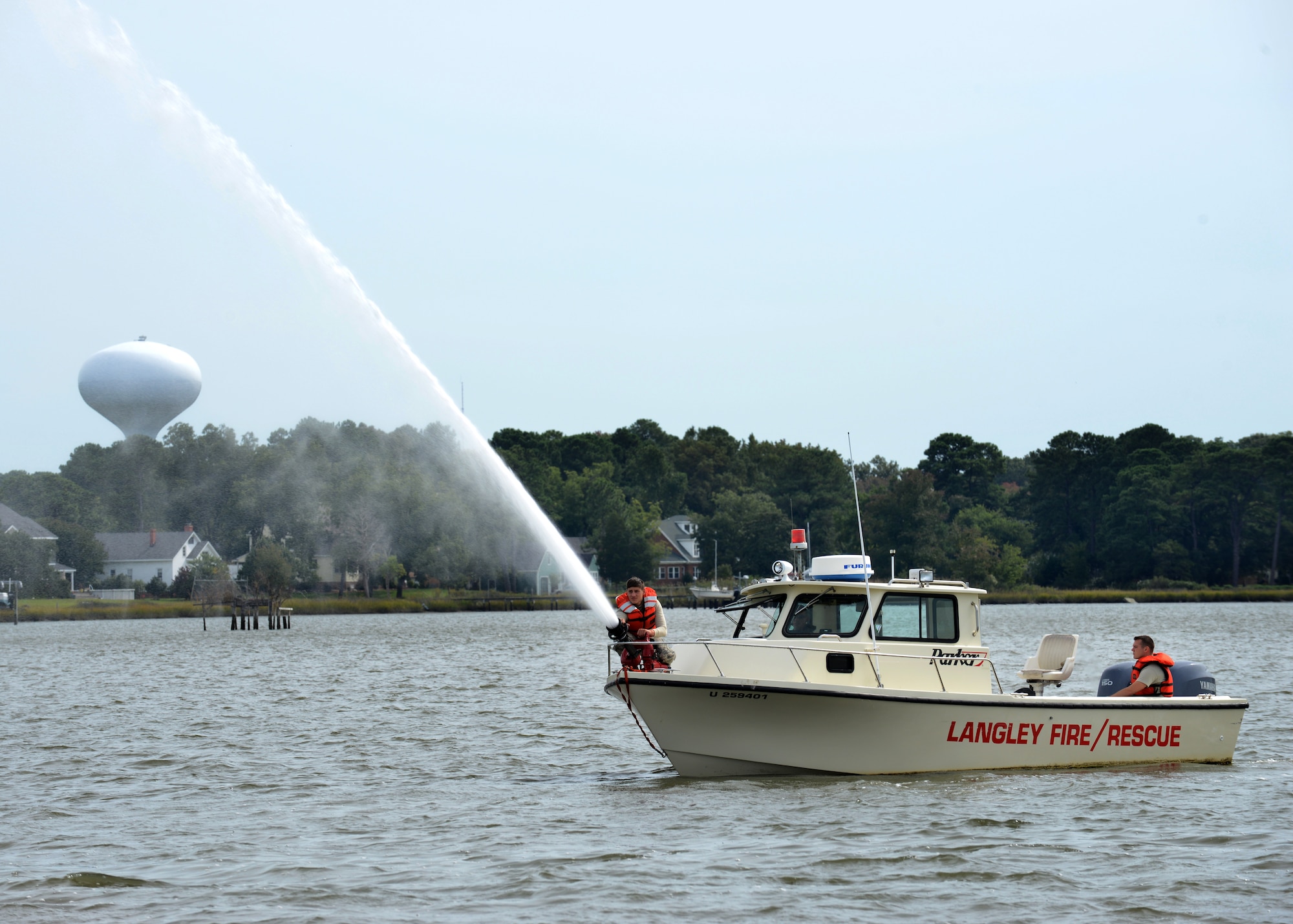 U.S. Air Force Airman 1st Class Scott Kolar, 633rd Civil Engineer Squadron firefighter, shoots water from the Langley Fire Rescue boat during training in Southwest Branch Back River near Langley Air Force Base, Va., Oct. 7, 2014. Several 633rd CES firefighters trained on the pump, which is used in the case of a shoreline fire. (U.S. Air Force photo by Airman 1st Class Devin Scott Michaels/Released)