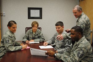 U.S. Air Force Master Sgt. Jena Brooks, far left, 480th Intelligence, Surveillance and Reconnaissance Wing training superintendent and other members of the Wingman Tactics Team look over best practices submitted by Airmen, Oct. 15, 2014. Senior non-commissioned officers from the wing recently created the Wingman Tactics Review Process to collect and review best practices and disseminate them throughout the wing. (U.S. Air Force photo by Marge McGlinn)