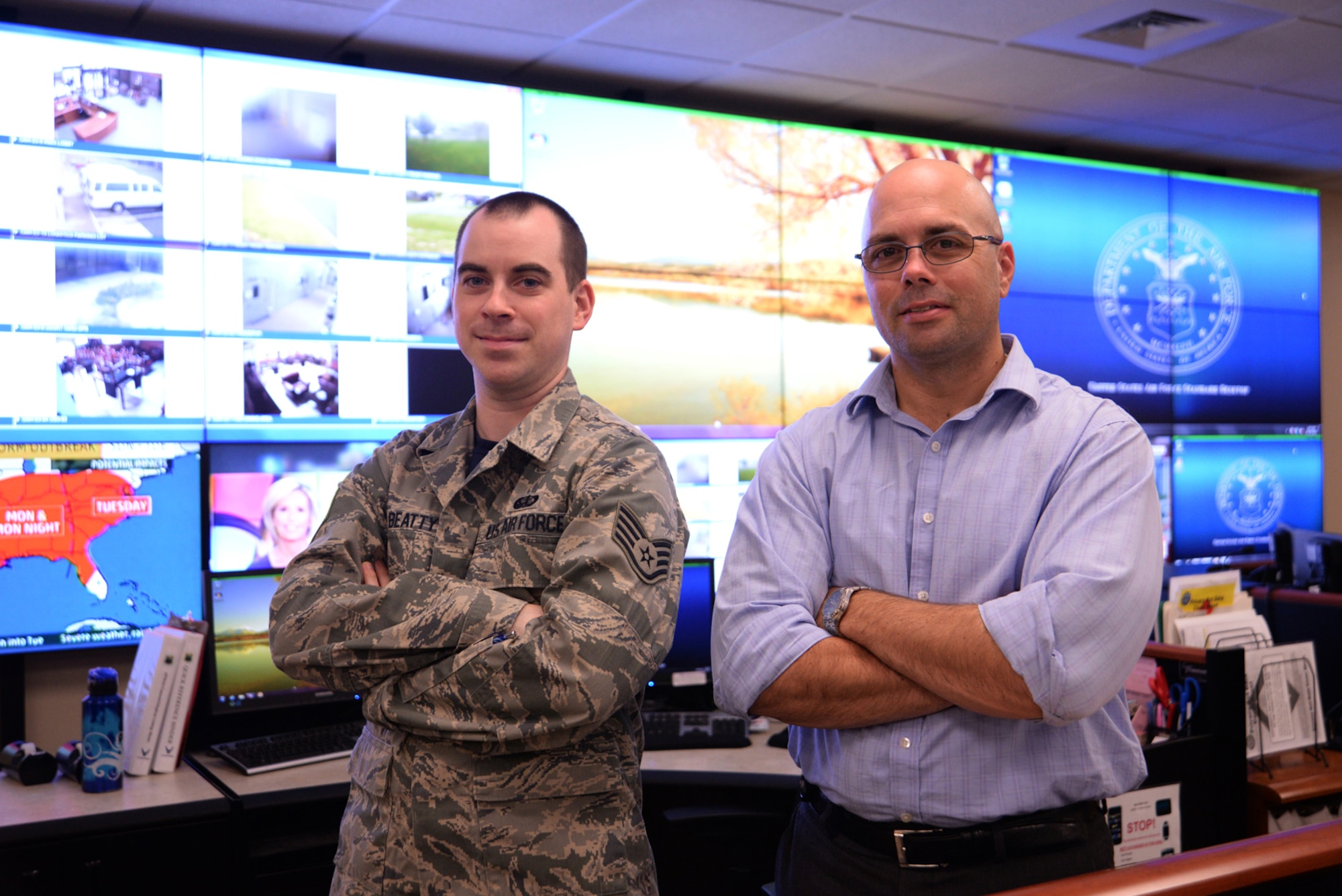 Controllers Staff Sgt. Jordan Beatty and Brent Blankenship, Air Force Mortuary Affairs Operations Command, Control and Communication, pose in the mortuary’s operations center Oct. 10, 2014.  Beatty is deployed from the 87th Force Support Squadron, Joint Base McGuire-Dix-Lakehurst, N.J., and Blankenship has worked in C3 as a civilian since 2009. (U.S. Air Force photo/Tech. Sgt. Myco Apat) 