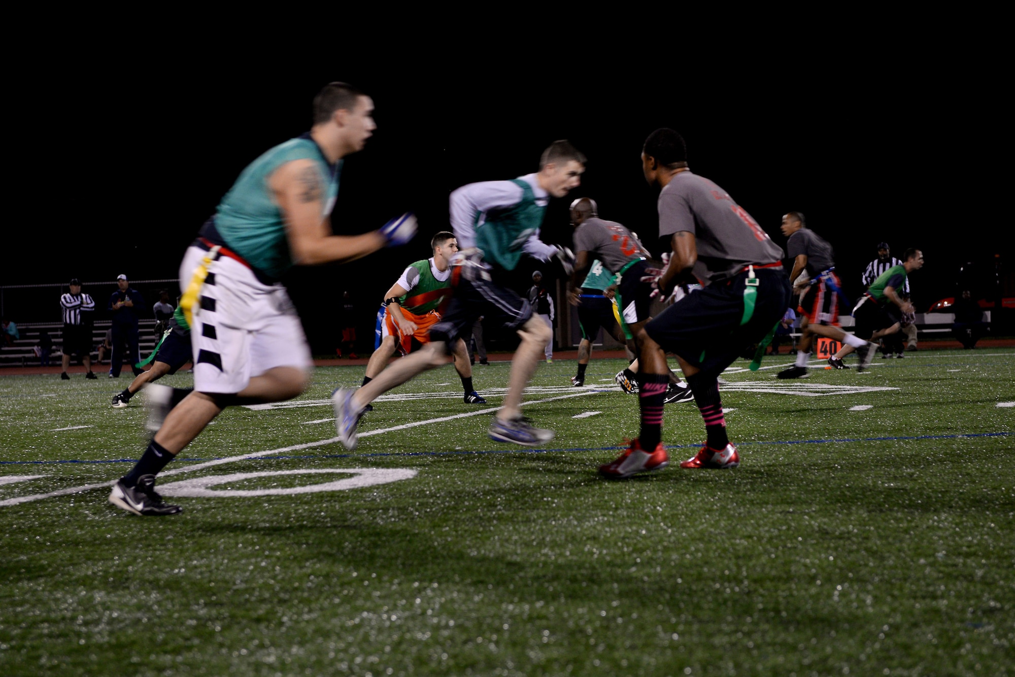 The 635th Supply Chain Operations Group plays the 375th Operations Support Squadron in a game of flag football Oct. 8, 2014 at Scott Air Force Base, Ill. This is the fifth year the SCOG team has incorporated pink in their attire during a game to promote Breast Cancer Awareness. (U.S. Air Force photo/ Airman 1st Class Kiana Brothers)