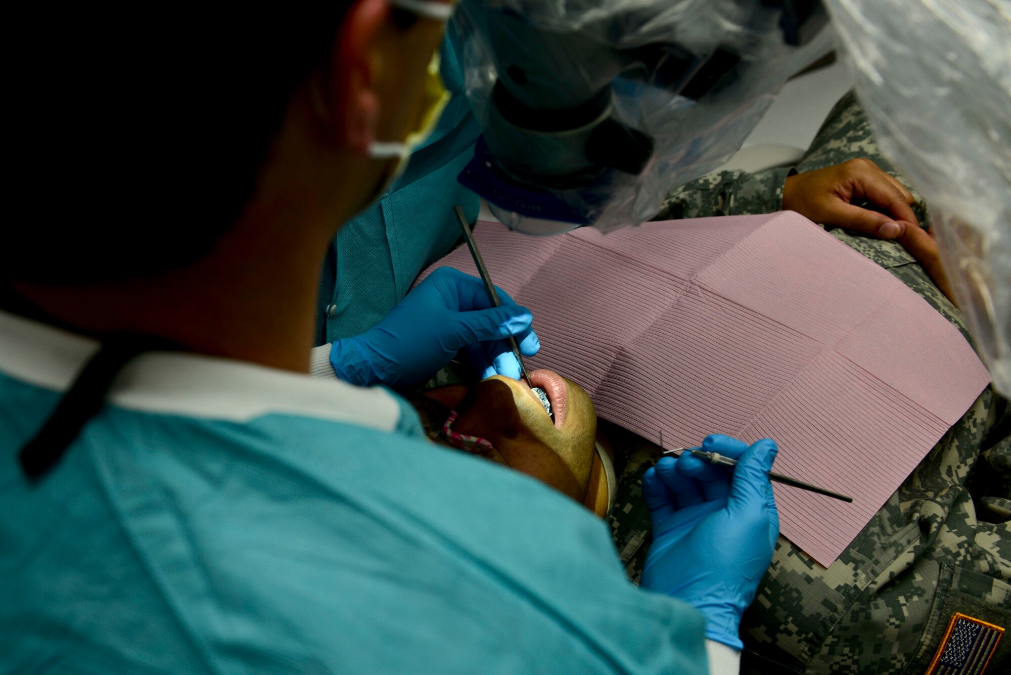 U.S. Army Maj. Byran Horspool, Dental Command endodontist, examines a patient’s mouth through a microscope at Fort Eustis, Va., Oct. 15, 2014. The microscope allows for the dentist to see 25-times closer. (U.S. Air Force photo by Airman 1st Class Kimberly Nagle/Released)