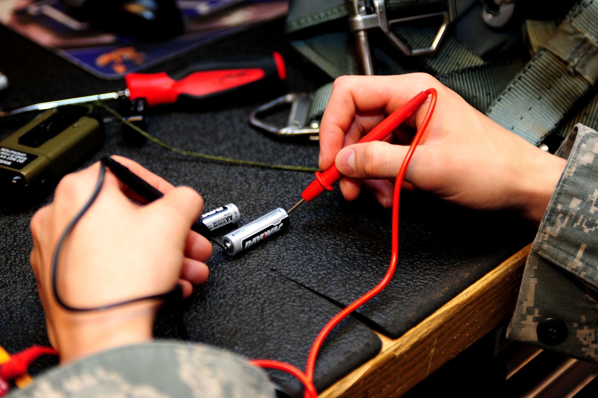 U.S. Air Force Airman 1st Class Patrick Long, 1st Operations Support Squadron aircrew flight equipment apprentice, checks a parachute’s battery supply at Langley Air Force Base, Va., Oct. 15, 2014. AFE Airmen are responsible for helmets, oxygen masks, parachutes, flotation devices, survival kits, night vision goggles and other types of AFE equipment. (U.S. Air Force photo by Airman 1st Class Areca T. Wilson/Released) 