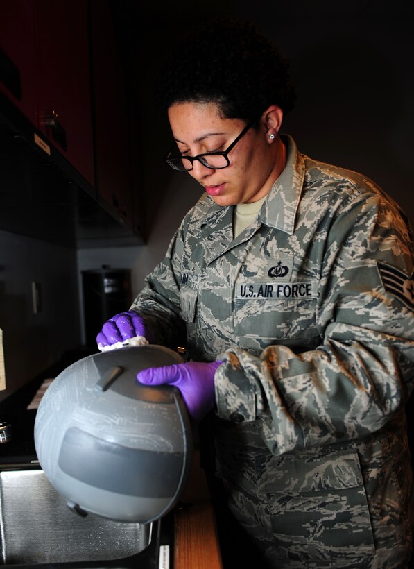 U.S. Air Force Staff Sgt. Christine Lozado, 1st Operations Support Squadron aircrew flight equipment craftsman, conducts a 30-day inspection on a HGU-55/P, or pilot’s helmet, at Langley Air Force Base, Va., Oct. 15, 2014. The pilot’s helmet, along with a parachute and survival kit, are considered life-saving flight equipment. (U.S. Air Force photo by Airman 1st Class Areca T. Wilson/Released) 