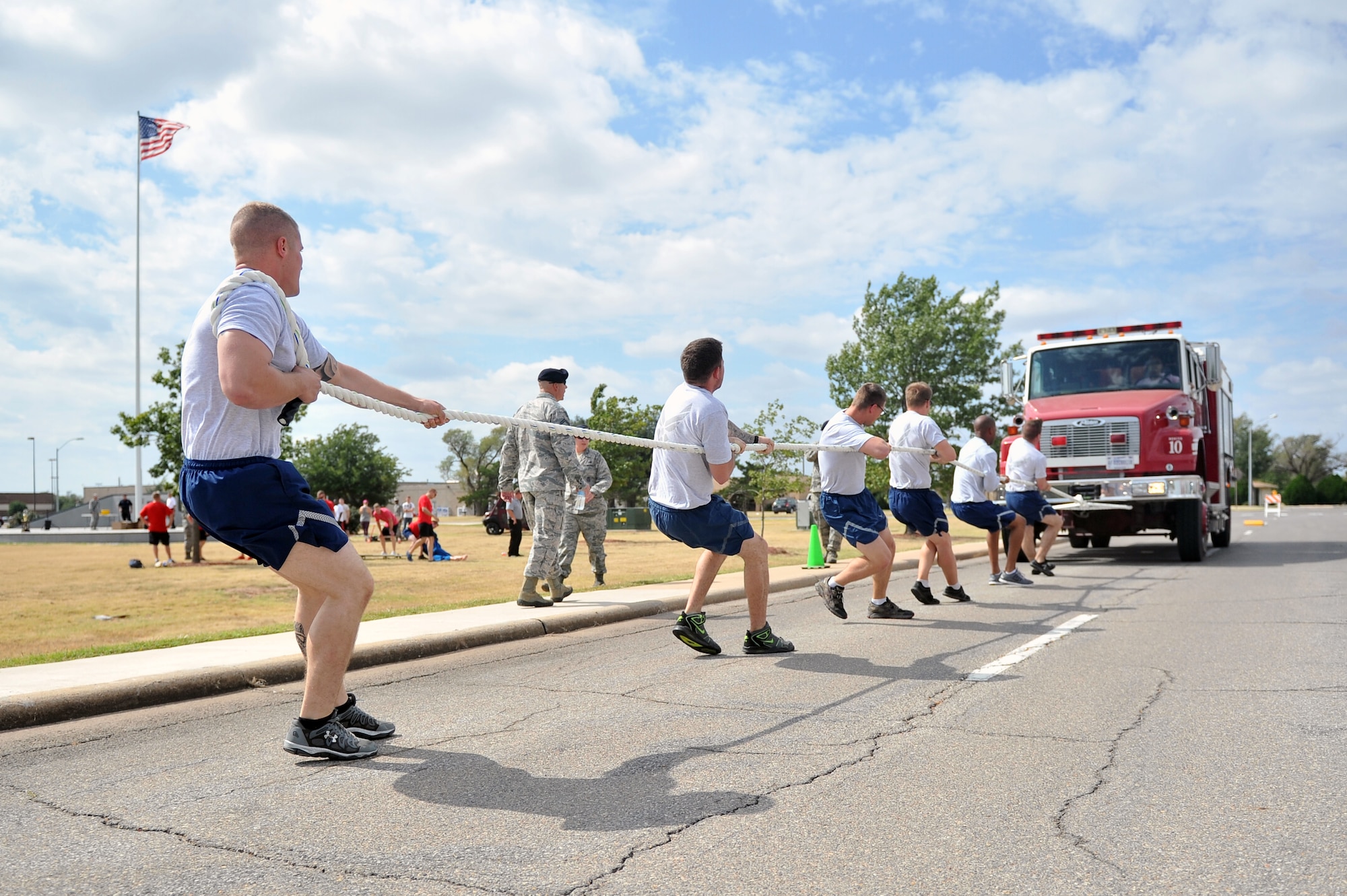 ALTUS AIR FORCE BASE, Okla. – Airmen from the 97th Security Forces Squadron pull a fire truck during this year’s Fire Prevention Week fire muster Oct. 9, 2014. The fire muster consisted of several events ranging from a fire-hose roll up to a litter carry. The 97th SFS took first place in this year’s fire muster competition. (U.S. Air Force photo by Senior Airman Dillon Davis/Released)
