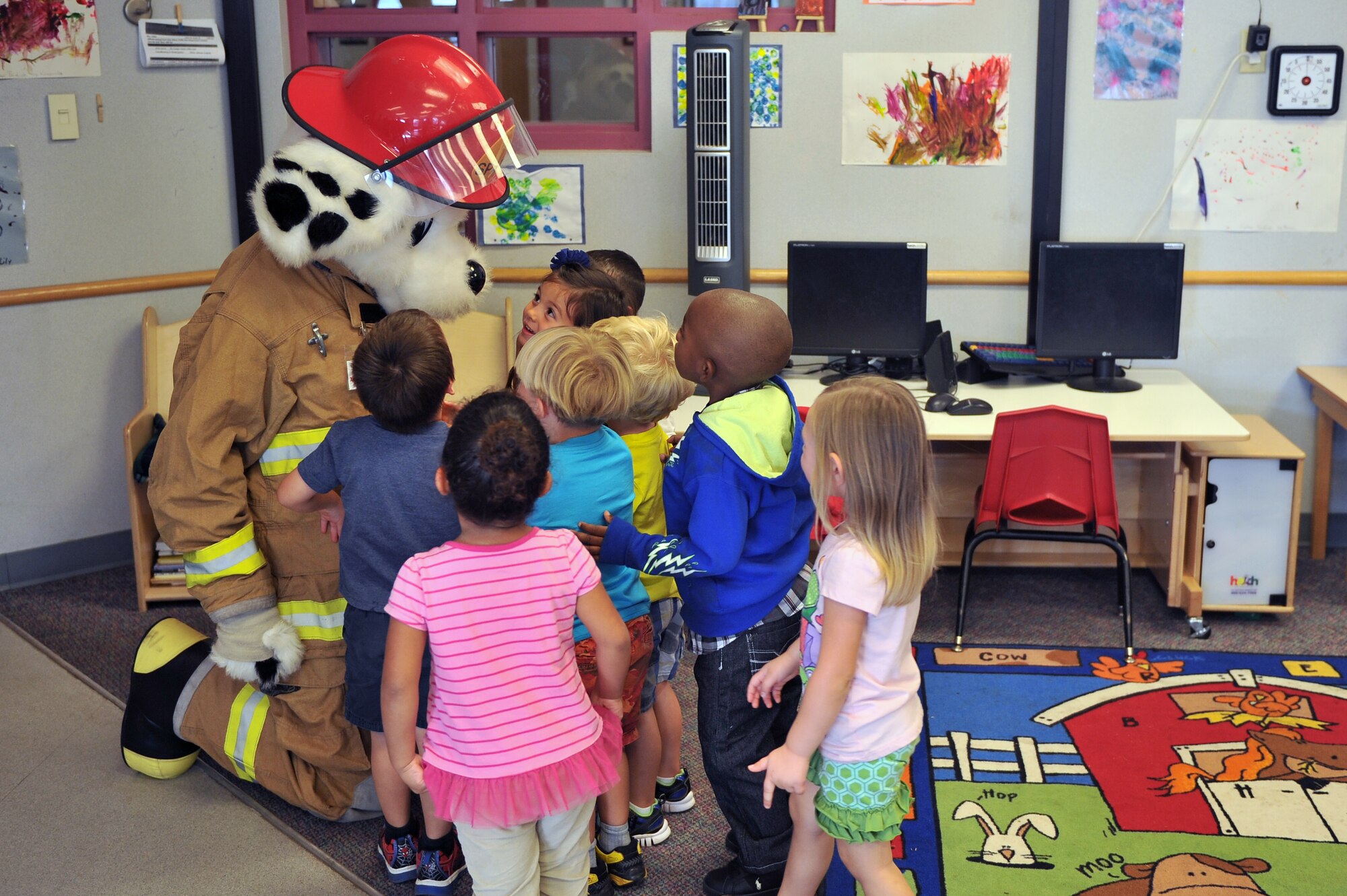 ALTUS AIR FORCE BASE, Okla. – Children greet Sparky during a visit to the Altus AFB child development center Oct. 7, 2014. Sparky and members of the 97th Civil Engineer Squadron Fire Department visited the CDC to introduce young children to fire safety and prevention. (U.S. Air Force photo by Senior Airman Dillon Davis/Released)