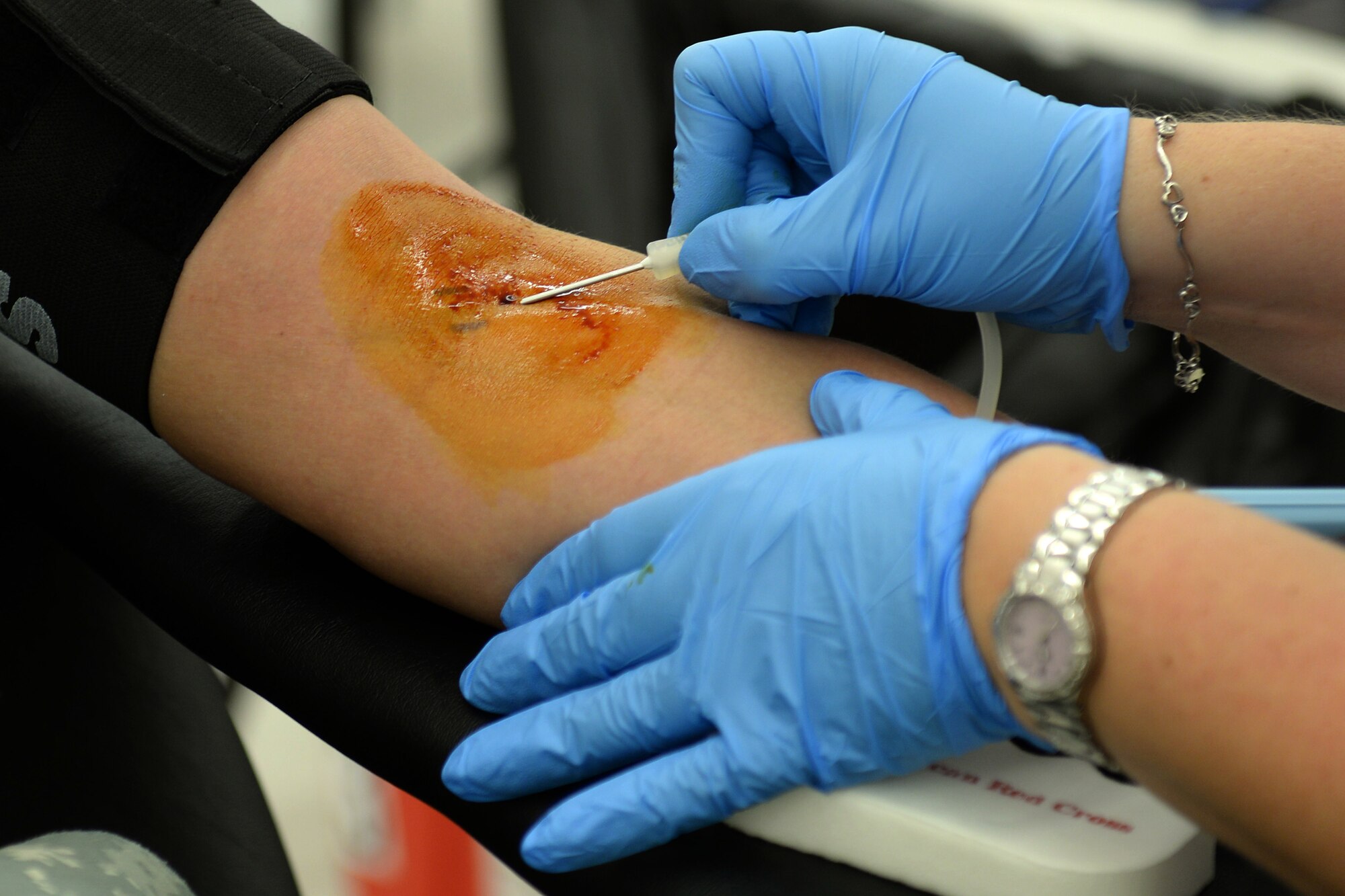 Krissy Calvert, American Red Cross technician, inserts a needle into the arm of U. S. Army Staff Sgt. Jason Panergo, 128th Aviation Brigade weapons instructor, at a blood drive held at Fort Eustis, Va., Oct. 15, 2014. Donors can schedule an appointment or walk in to donate during the quarterly blood drives. (U.S. Air Force photo by Staff Sgt. Teresa J. Cleveland/Released)