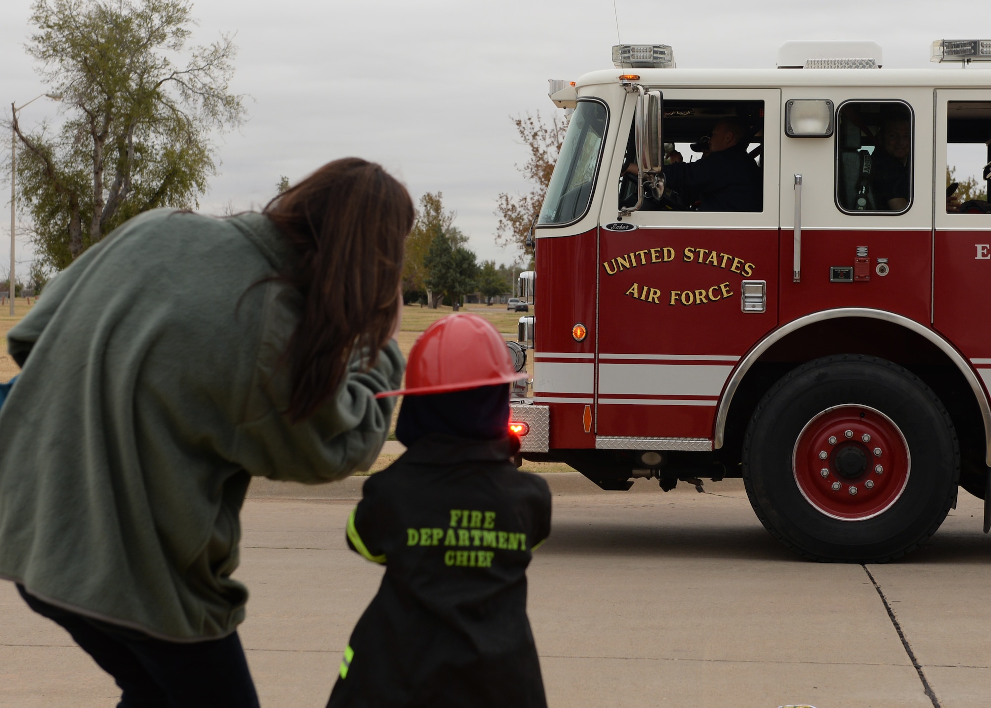 ALTUS AIR FORCE BASE, Okla. – A family watches the parade for Fire Prevention Week Oct. 11, 2014. The week ended with a five and ten kilometer race, a parade through base housing and an open house at the fire department. (U.S. Air Force photo by Airman 1st Class Nathan Clark/Released)