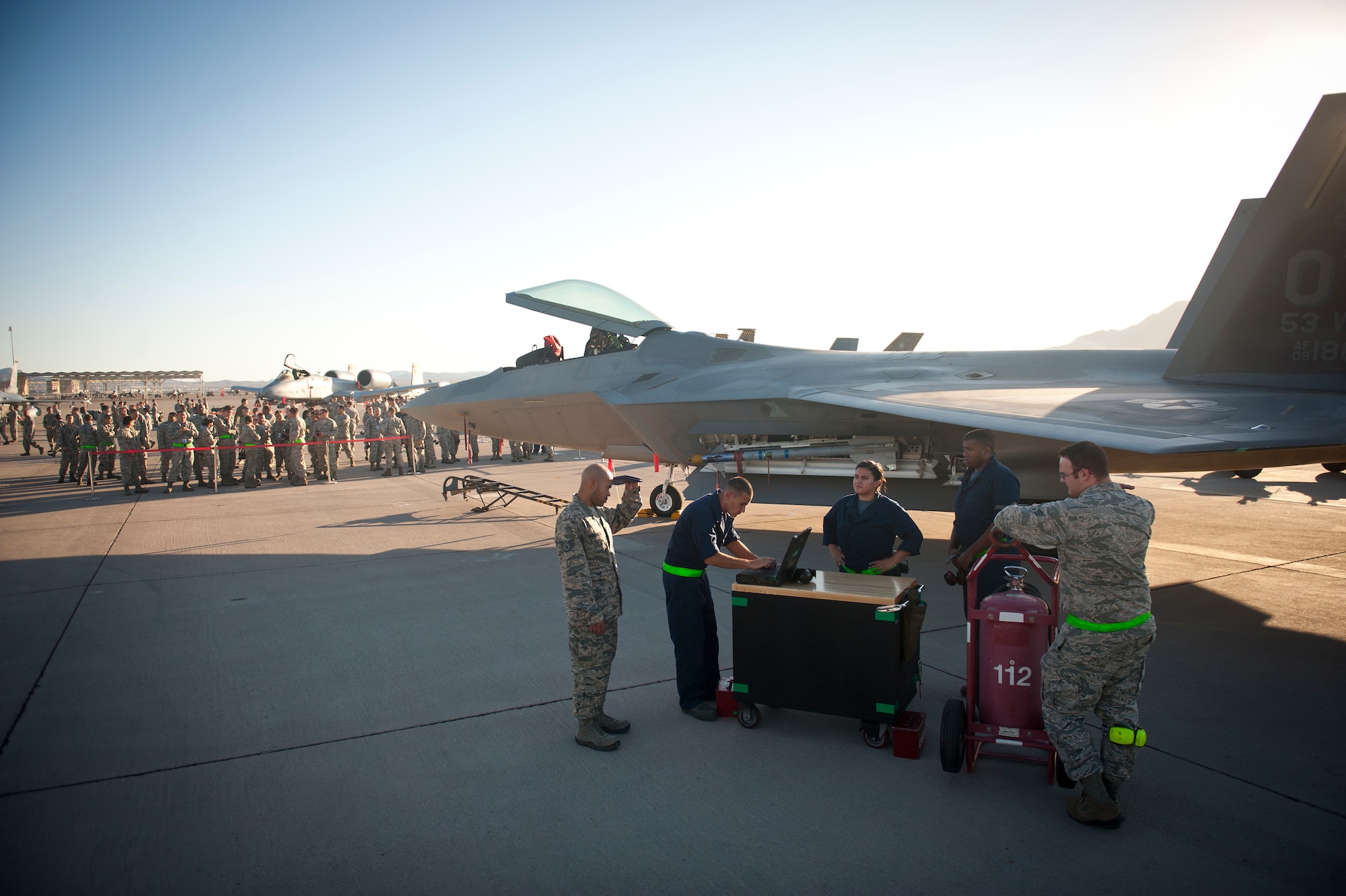 Weapons loaders and inspectors from the 57th Aircraft Maintenance Squadron Raptor Aircraft Maintenance Unit wait at their work station during a quarterly weapons load crew competition at Nellis Air Force Base, Nev., Oct. 10, 2014. In addition to the weapons loading, crews are also inspected on their dress and appearance, and have their tool boxes inspected for good order to determine the 57th Maintenance Group’s best weapons load crew of the quarter. (U.S. Air Force photo by Airman 1st Class Thomas Spangler)