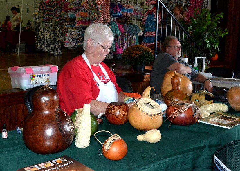 Peggy Beauvais, 23d Force Support Squadron Airman and Family Readiness Center director, decorates gourds at the Flatlanders Frolic arts and crafts festival, Oct. 11, 2014, in Lakeland, Ga.  Beauvais uses different techniques such as burning, chipping, painting, staining, beading and carving to make various designs in her home-grown gourds. The hobby developed about four years ago when she saw the designs at a gourd show.  Beauvais previously worked as the transition assistance manager at Scott Air Force Base, Ill., before her reassignment to Moody Air Force Base, Ga. (U.S. Air Force photo by Master Sgt. Sonny Cohrs/released)