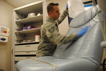 Wearing blue latex gloves for protection, Staff Sgt. Michael Shea, 319th Medical Operation Squadron NCO in-charge of primary care, uses disinfectant wipes to sterilize and prepare a consultation room for the next patient Oct. 9, 2014, at the family health clinic on Grand Forks Air Force Base, N.D. Routine procedures such as this one are practiced and enforced by Shea and his team in order to prevent the spread of germs and illnesses. (U.S. Air Force photo/Staff Sgt. Luis Loza Gutierrez)