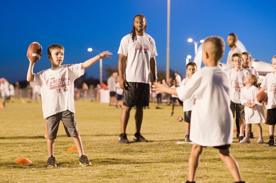 Larry Fitzgerald, seven time pro-bowl wide receiver for the Arizona Cardinals, coaches military children through football drilss during a two-day football camp held at Luke Air Force Base, Arizona, Oct. 13, 2014. The camp ran by ProCamps Worldwide, specialized in football fundamentals, with campers receiving instruction from Fitzgerald and football coaches from the local area. (U.S. Air Force photo/Staff Sgt. Staci Miller)
