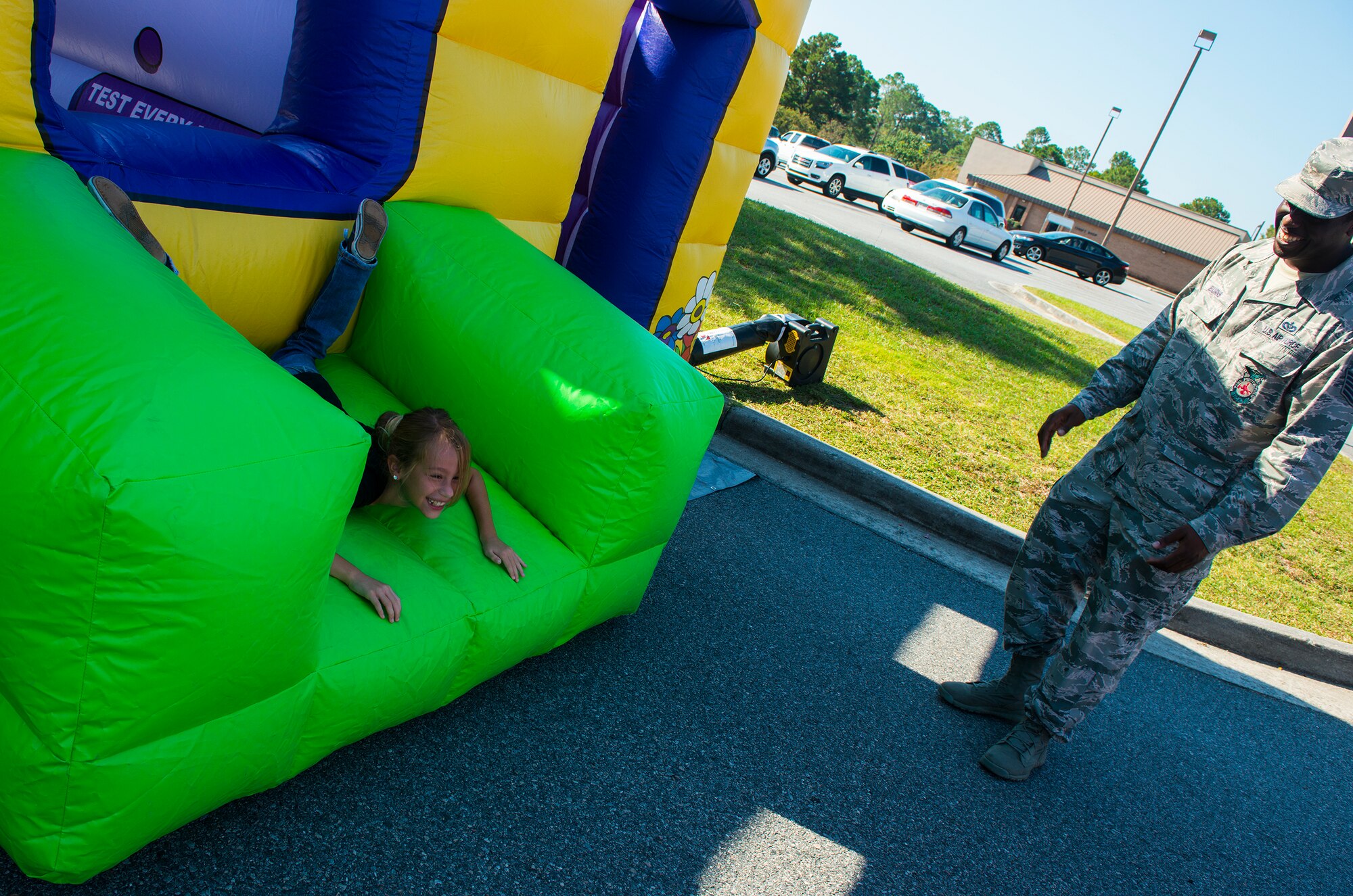 Miranda Crane, niece of Senior Master Sgt. Alfred Venditti, 23d Maintenance Group, laughs along with Tech. Sgt. Phillip Burns, 23d Civil Engineer Squadron fire inspector, after jumping through a window during the Fire Prevention Week Open House Oct. 11, 2014, at Moody Air Force Base Ga. Burns demonstrated the importance of knowing what to do in a fire and how to escape if the room was on fire. (U.S. Air Force photo by Airman 1st Class Ceaira Tinsley/Released)