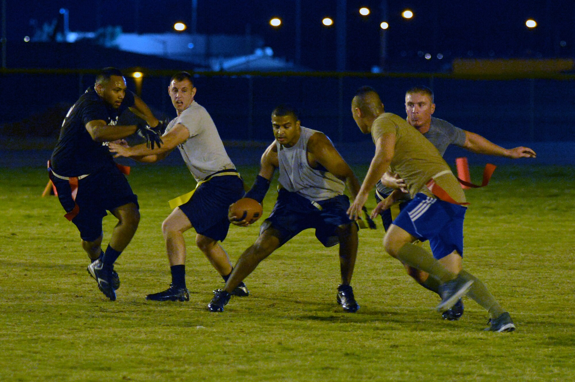 Antonio Flores, Detachment 12, 372nd Training Squadron, scrambles around the defenders to gain a few yards Sept. 29 at Luke Air Force Base. Flores led the Det. 12 team to victory against the 56th Fighter Wing staff agencies team. (U.S. Air Force photo/Airman 1st Class Pedro Mota)