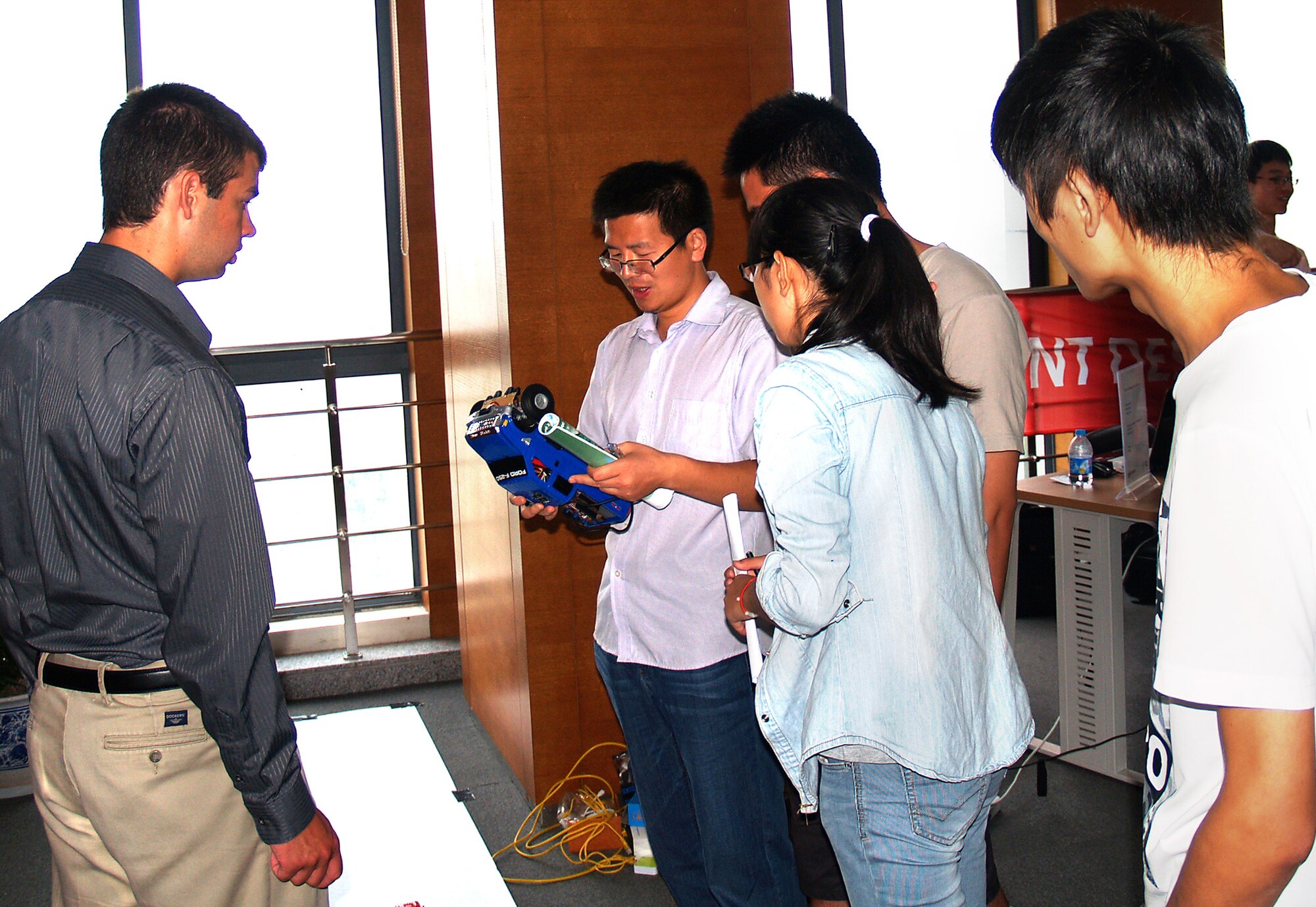 Cadet 3rd Class Dominic Celiano (left), presents his automated remote control car during the International Diligent Design Contest in Shanghai, China, this summer. Celiano took a toy car, added motors to drive the wheels, mounted various sensors to it, and developed a control algorithm to allow the car to follow a set path and avoid obstacles. The cadet's project earned 10th place in the contest. (Courtesy photo)