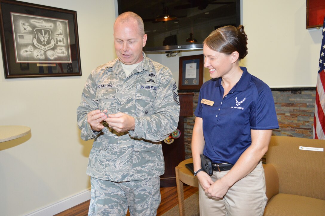 Air National Guard Command Chief Master Sgt. James Hotaling tells Staff Sgt. Angela Layton, enlisted aide to the 1st Air Force commander, about his coin prior to presenting it to her during his recent visit. Layton was recognized by Hotaling for her selection as Air Combat Command's Enlisted Aide of the Year. Hotaling visited 1st Air Force and the 601st Air and Space Operations Center October 9-10.  (Photo by Mary McHale)