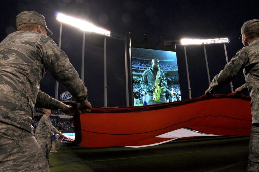 Airmen from the 442d Fighter Wing waved the giant flag on the field of Royals stadium October 14, 2014 with their counterparts from the Army and active duty Air Force out of Whiteman Air Force Base. More than 100 volunteers from Whiteman AFB participated in the flag detail that accompanied the national anthem and an aircraft flyover that open the third game of the American League Central Series. The anthem was performed by saxophone, as a nod to Kansas City’s cultural jazz heritage. (Air Force photo by Tech. Sgt. Emily F. Alley)