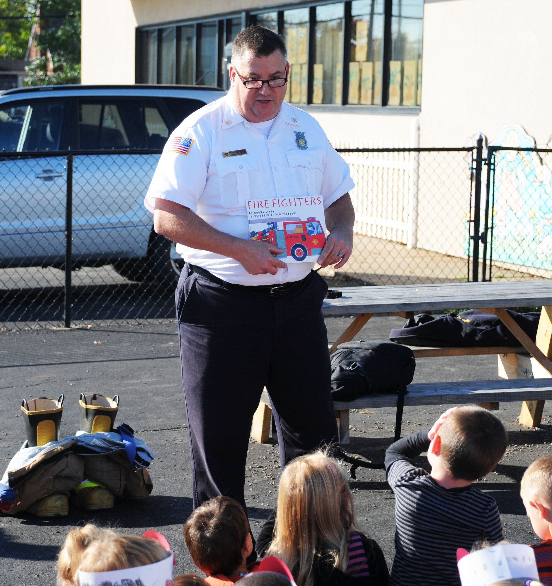 John P. Schultz, Asst. Chief, Fire Prevention, 914th Mission Support Group, reads to children at a local school, October 9 2014. Shultz was teaching the students basic fire safety for Fire Prevention Week which ran from Oct. 5-11. (U.S. Air Force Photo by Staff Sgt. Matthew Burke)