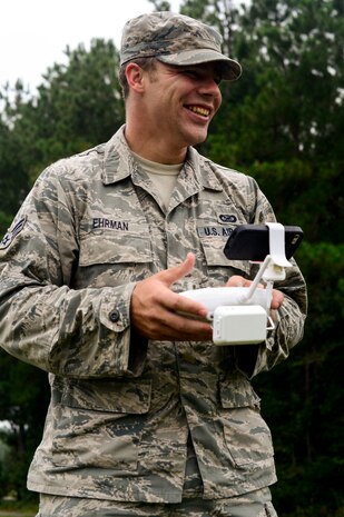 Senior Airman Rion Ehrman, 1st Combat Camera Squadron Combat Broadcaster, operates the controls of an unmanned aerial photo/video quad copter during a ruck march Sept 26, 2014, on Joint Base Charleston, S.C. A ruck march is a fast-paced hike done while carrying heavy weight. The unmanned quad copter is a new capability for the 1st CTCS and operators practiced using the quad copter to see how it could benefit combat cameramen in deployed environments. (U.S. Air Force photo/Senior Airman Nicholas Byers)