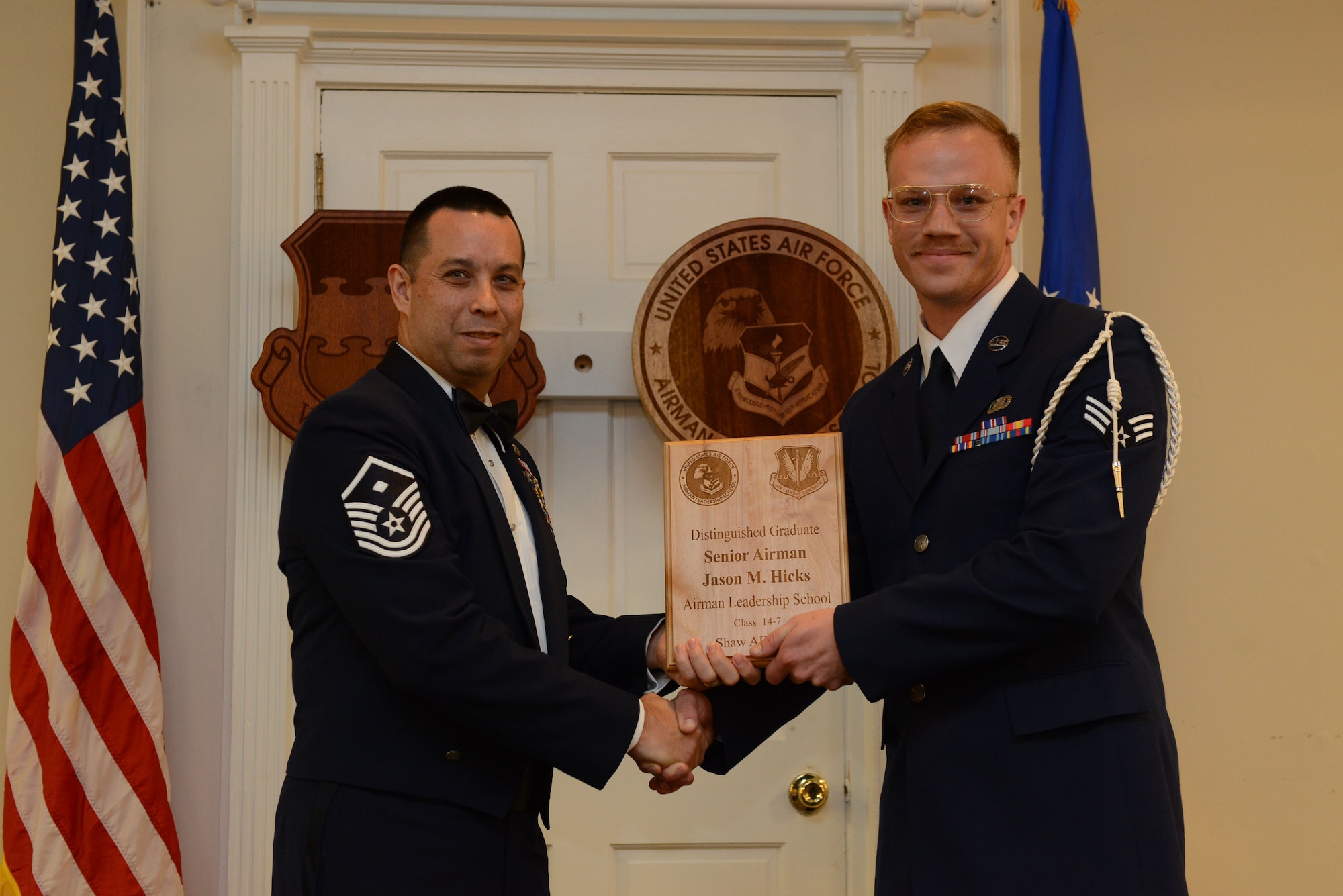 U.S. Air Force Senior Airman Jason Hicks, 3rd Intelligence Squadron (right), receives a distinguished graduate Award for class 14-7 of the Senior Master Sgt. David B. Reid Airman Leadership School from Master Sgt. David Williams, Detachment 1, 609th Air and Space Operations Center first sergeant, at Shaw Air Force Base, S.C., Oct. 9, 2014. Distinguished graduate awards are given to the top 10 percent of the class for total point accumulation. (U.S. Air Force photo by Airman 1st Class Diana M. Cossaboom/Released)