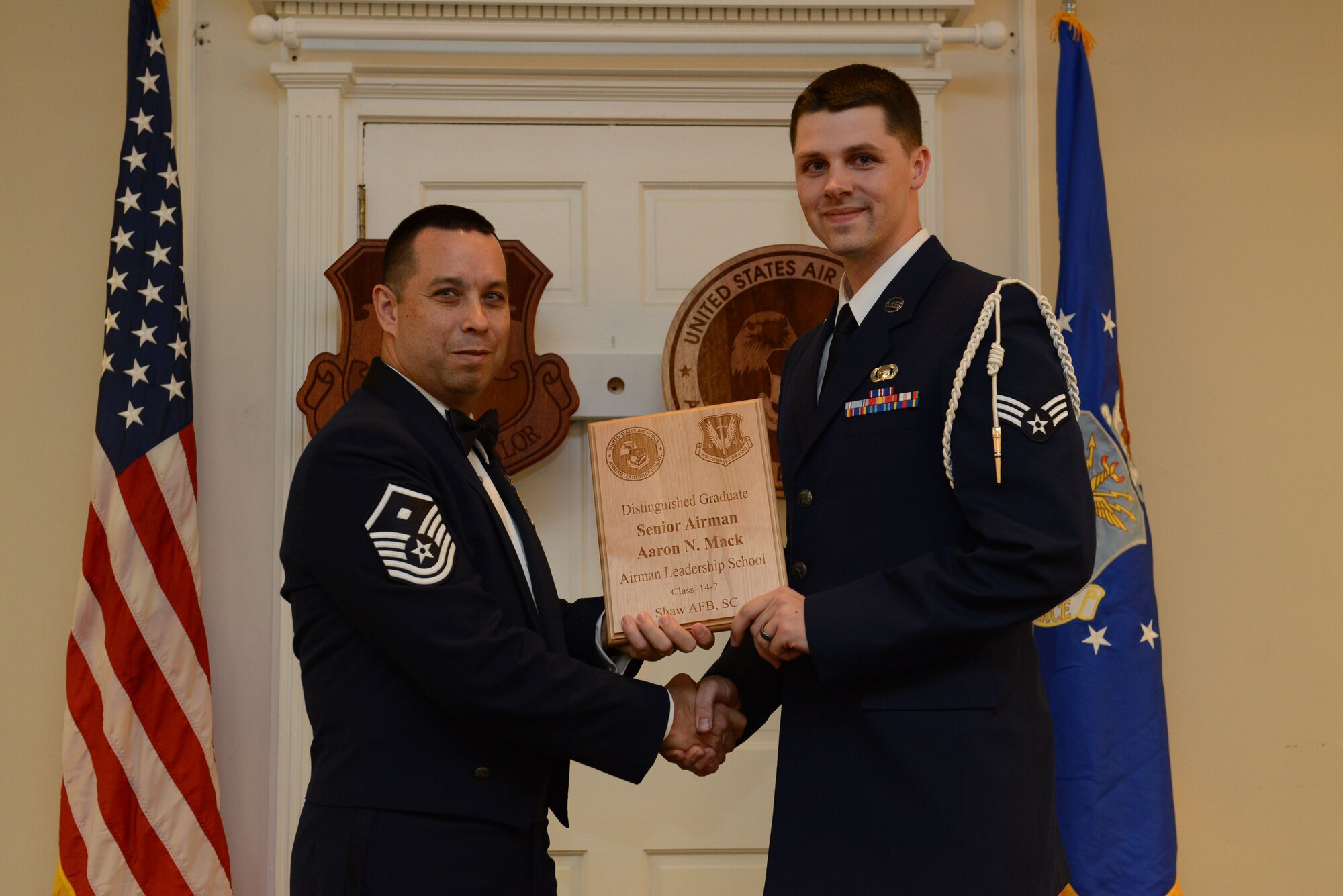 U.S. Air Force Senior Airman Aaron Mack, 31st Intelligence Squadron (right), receives a Distinguished graduate Award for class 14-7 of the Senior Master Sgt. David B. Reid Airman Leadership School from Master Sgt. David Williams, Detachment 1, 609th Air and Space Operations Center first sergeant, at Shaw Air Force Base, S.C., Oct. 9, 2014. Distinguished graduate awards are given to the top 10 percent of the class for total point accumulation. (U.S. Air Force photo by Airman 1st Class Diana M. Cossaboom/Released)