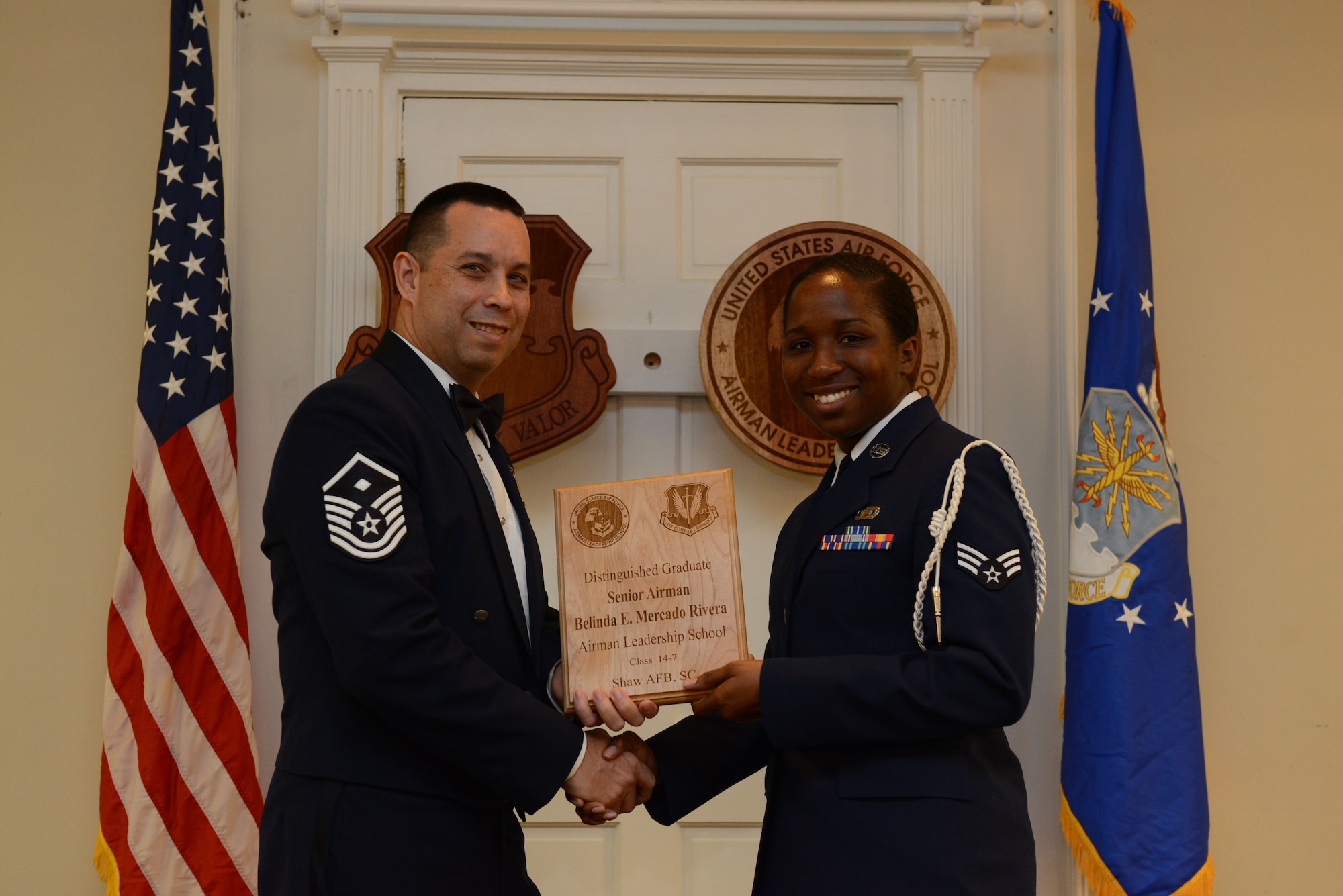 U.S. Air Force Senior Airman Belinda Mercado Rivera, 31st Intelligence Squadron (right), receives a distinguished graduate Award for class 14-7 of the Senior Master Sgt. David B. Reid Airman Leadership School from Master Sgt. David Williams, Detachment 1, 609th Air and Space Operations Center first sergeant, at Shaw Air Force Base, S.C., Oct. 9, 2014. Distinguished graduate awards are given to the top 10 percent of the class for total point accumulation. (U.S. Air Force photo by Airman 1st Class Diana M. Cossaboom/Released)