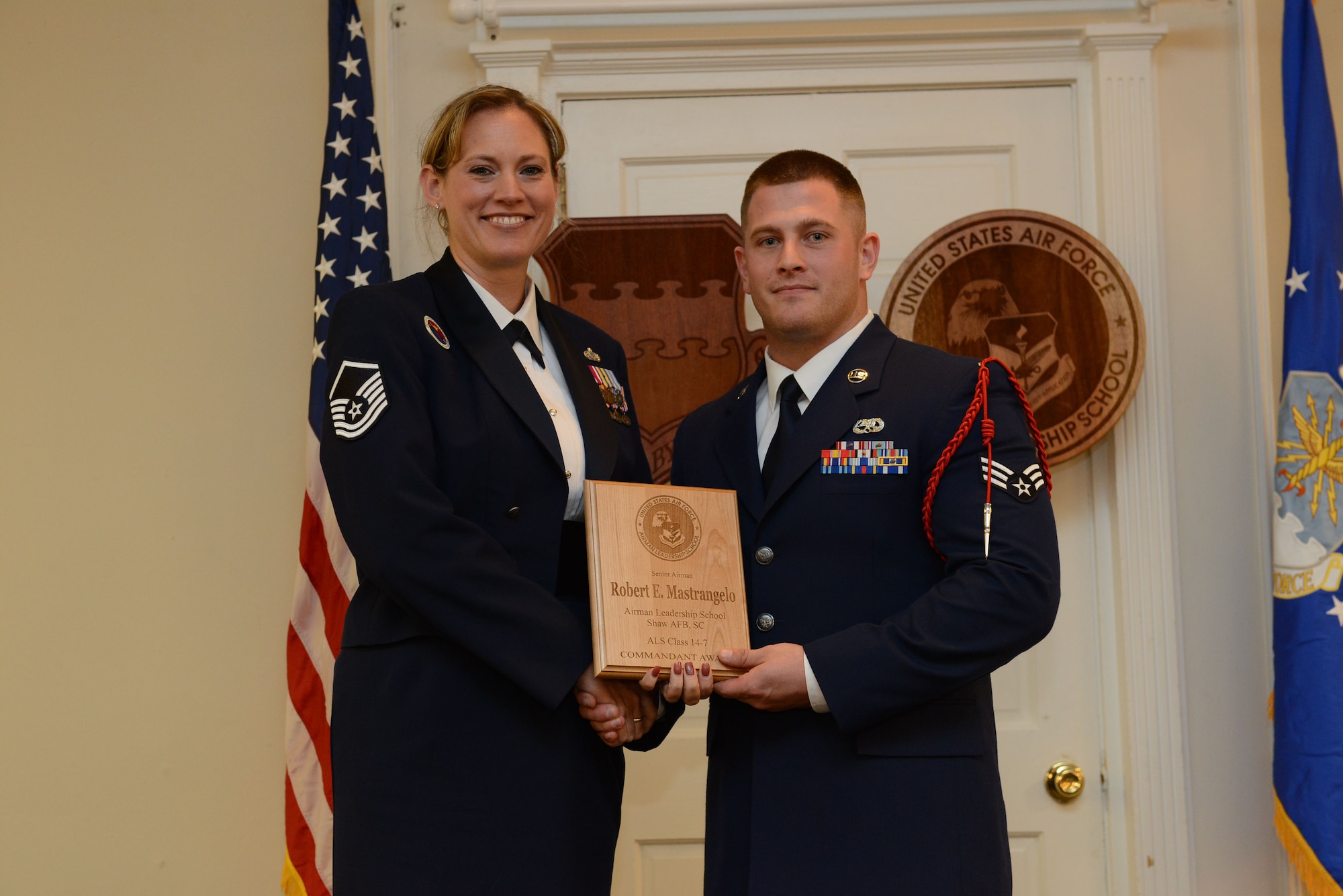 U.S. Air Force Senior Airman Robert Mastrangelo, Detachment 93, 495th Fighter Group (right), receives the Senior Master Sgt. David B. Reid Airman Leadership School Class 14-7, Commandant Award from Master Sgt. Lindsey Wolf, 20th Force Support Squadron ALS commandant, at Shaw Air Force Base, S.C., Oct. 9, 2014. The Commandant award is given to the student who most exemplifies professional military qualities as chosen by their peers, primary instructor, and ALS commandant. (U.S. Air Force photo by Airman 1st Class Diana M. Cossaboom/Released) 
