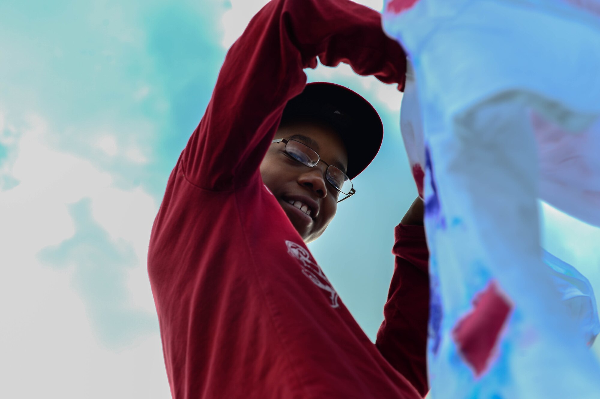 Arion Johnson, son of Lymas and U.S. Air Force Tech. Sgt. Demetris Johnson, 52nd Medical Operations Squadron pediatrics, helps hang shirts on a clothes line at the 52nd Force Support Squadron School Age Program building on Spangdahlem Air Base, Germany, Oct. 15, 2014. The Clothes Line Project is hosted by the 52nd Medical Operations Squadron Family Advocacy, which helps raise awareness for women who have died or have been victimized by domestic violence. This is the first year the clothes line was displayed at the School Age building. (U.S. Air Force Photo by Airman 1st Class Kyle Gese/Released)