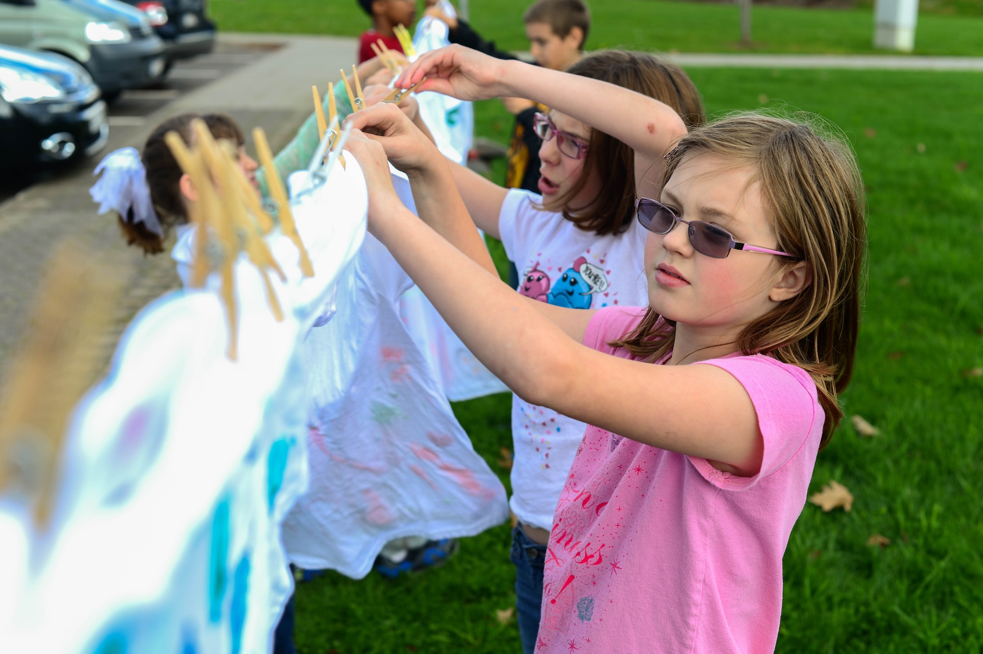 Shelby Carter, daughter of Wendy Joramo-Carter and Shane Carter, helps hang shirts on a clothes line at the school age building on Spangdahlem Air Base, Germany, Oct. 15, 2014. Children hung painted shirts to raise awareness for domestic violence. The 52nd Medical Operations Squadron Family Advocacy partnered with the 52nd Force Support Squadron School Age Program and Teen Center to educate children about preventing the violence. (U.S. Air Force photo by Airman 1st Class Kyle Gese/Released)