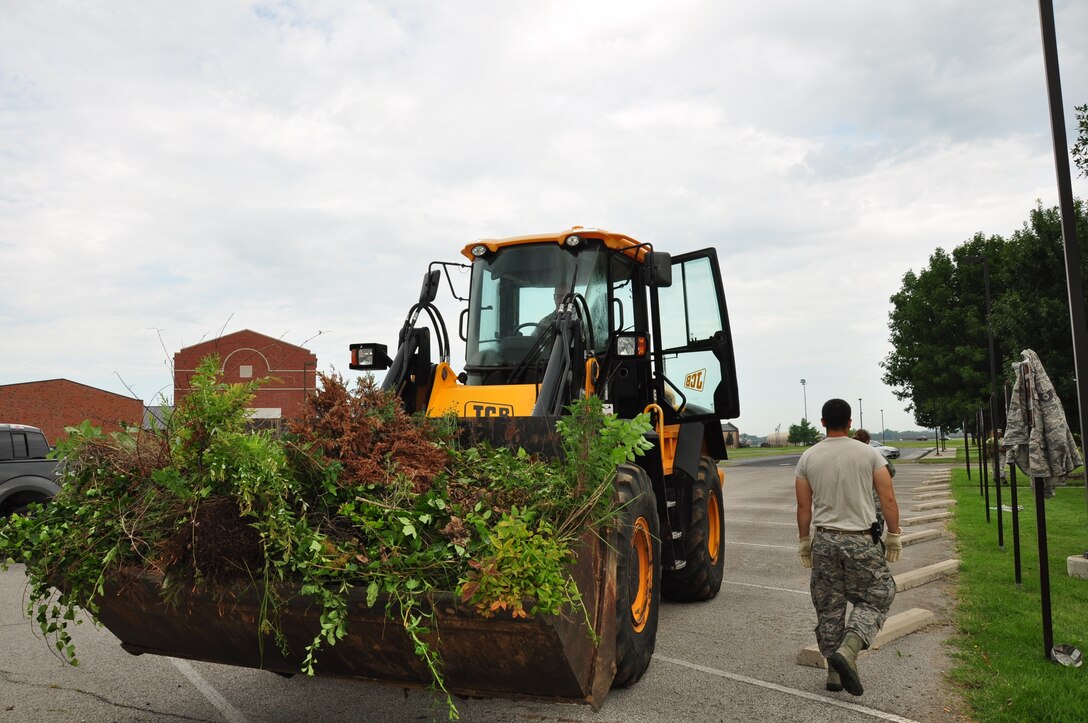 Civil engineers from the 932nd CE helped haul away old vegetation from in front of the headquarters building during a recent cleaning event at the 932nd Airlift Wing. Various staff and 932nd Airlift Wing members joined together to work on a self-help project cleaning the grounds in front of the wing headquarters building. A large amount of material was cleaned up and the results were quite positive, as seen by many visitors walking by the flagpole. (U.S. Air Force photo/Staff Sgt. Amber Hodges)