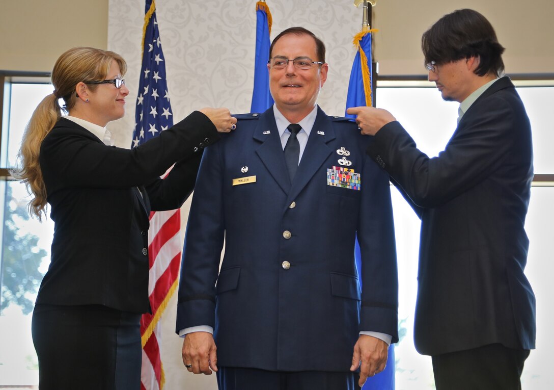 New eagle wings are pinned onto the outgoing commander of the Aircraft Maintenance Squadron at the 932nd Airlift Wing during the unit training assembly.  Newly promoted Col. Clifford Waller smiles upon receiving his promotion to full colonel.  (U.S. Air Force photo/Tech. Sgt. Christopher Parr)