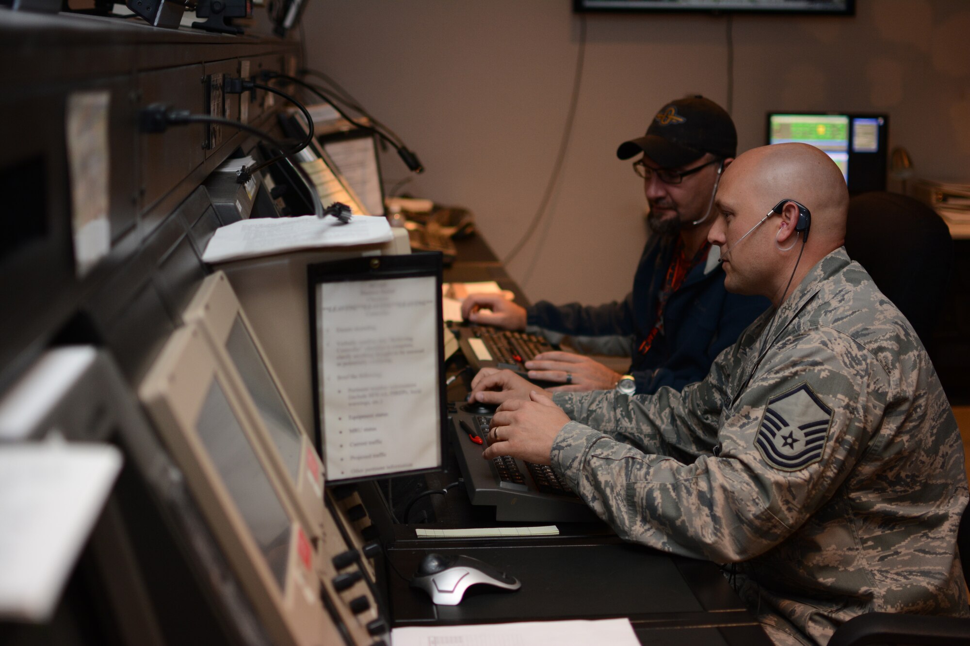 Master Sgt. Andrew Jackson, Combat Readiness Training Center RADAR approach control chief controller, and Jeff McCluskey, Federal Aviation Administration air traffic control specialist, work together to control airspace at the ATC center at Volk Field Air National Guard Base, in Camp Douglas, Wisconsin, Oct. 6, 2014. The FAA sent civilian ATC specialists to Volk Field following a fire at the Chicago ATC Center. Two of the FAA ATC specialists were also Volk Field guardsmen. (Air National Guard photo by Senior Airman Andrea F. Rhode)