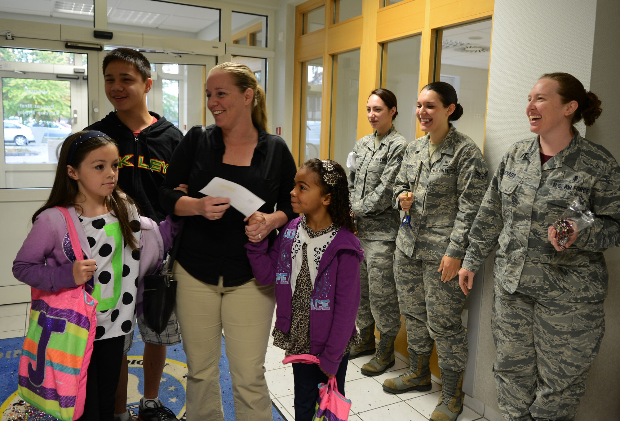Tech. Sgt. Tracy Love, 786th Force Support Squadron force management NCOIC, and family receive a United Service Organizations gift voucher from the 86th Dental Squadron during Customer Service Week on Ramstein Air Base, Germany, Oct. 10, 2014. The 86th MDG celebrated Customer Service Week to recognize their staff members for a job well done. (U.S. Air Force photo/Senior Airman Hailey Haux)