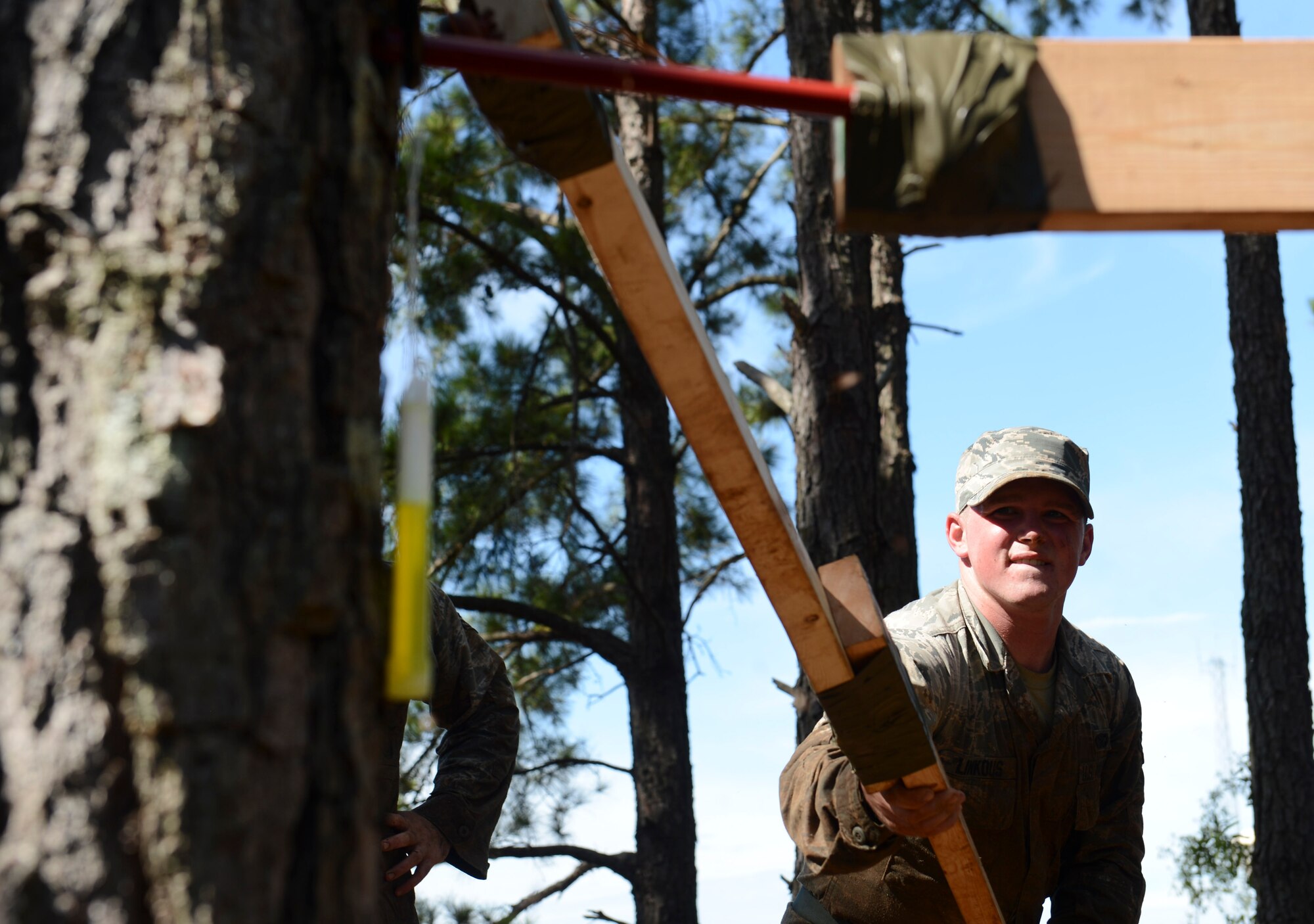 U.S. Air Force Airman 1st Class Logan Linkous, 20th Security Forces Squadron entry controller, attempts to retrieve a glow stick using only materials provided at Shaw Air Force Base, S.C., Oct. 8, 2014. During this obstacle, participants used various provided materials to remove one glow stick from a contaminated area while maintaining a safe distance. (U.S. Air Force photo by Senior Airman Tabatha Zarrella/Released)