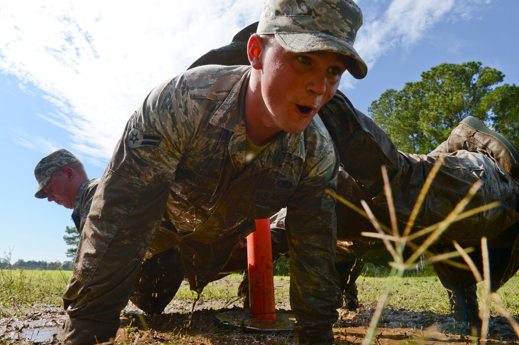 U.S. Air Force Airman 1st Class Logan Linkous, 20th Security Forces Squadron entry controller, performs a four-man push-up with three other teammates at Shaw Air Force Base, S.C., Oct. 8, 2014. The four-man push-up was part of the Defenders Edge Challenge in which 20th SFS Airmen completed obstacles that tested their physical fitness, mental, and shooting abilities. (U.S. Air Force photo by Senior Airman Tabatha Zarrella/Released)