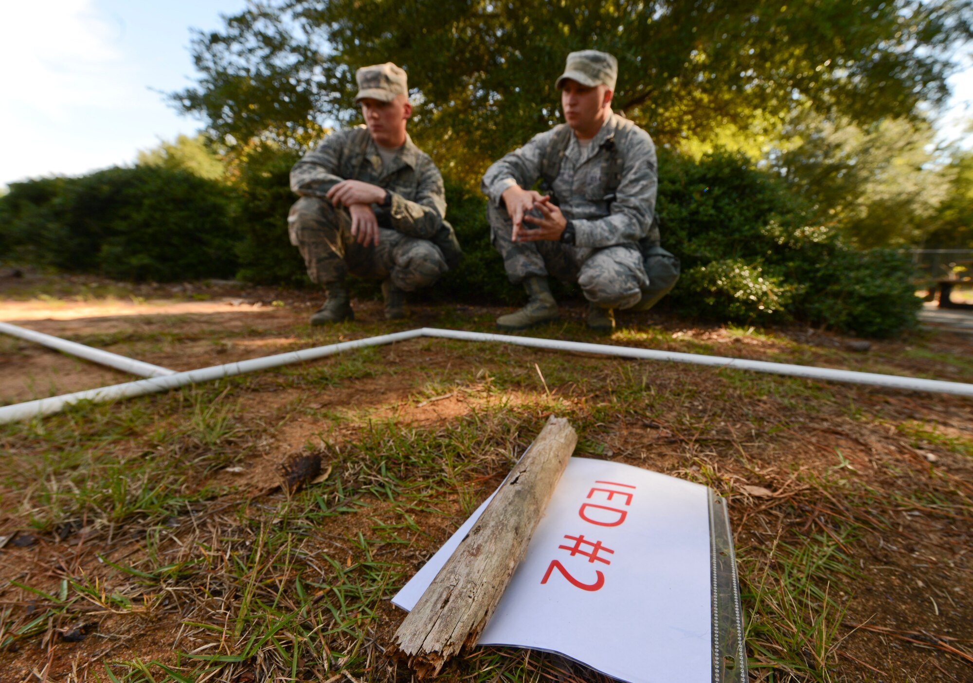 U.S. Air Force Airman 1st Class Robert Rosensteel and Airman 1st Class Jeffrey Mabry, 20th Security Forces Squadron entry controllers, contemplate how to complete a brain teaser obstacle at Shaw Air Force Base, S.C., Oct. 8, 2014. At this particular obstacle, the participants were given two brain teasers in which they either had to complete and pass or fail the obstacle. (U.S. Air Force photo by Senior Airman Tabatha Zarrella/Released)