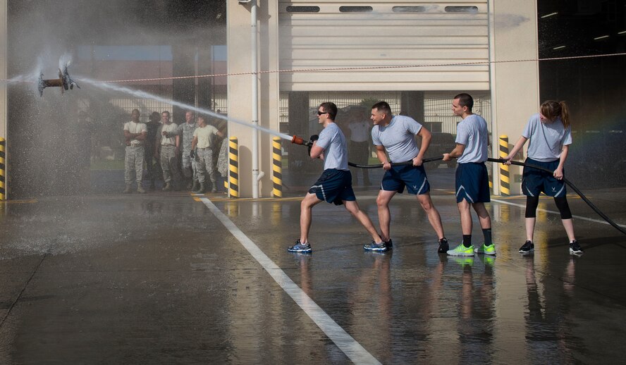 Airmen participate in the water joust during the Fire Prevention Week Fire Muster Competition at Yokota Air Base, Japan, Oct. 10, 2014. Airmen had the opportunity to bond and meet others from different squadrons during the competition. (U.S. Air Force photo by Airman 1st Class Meagan Schutter/Released)