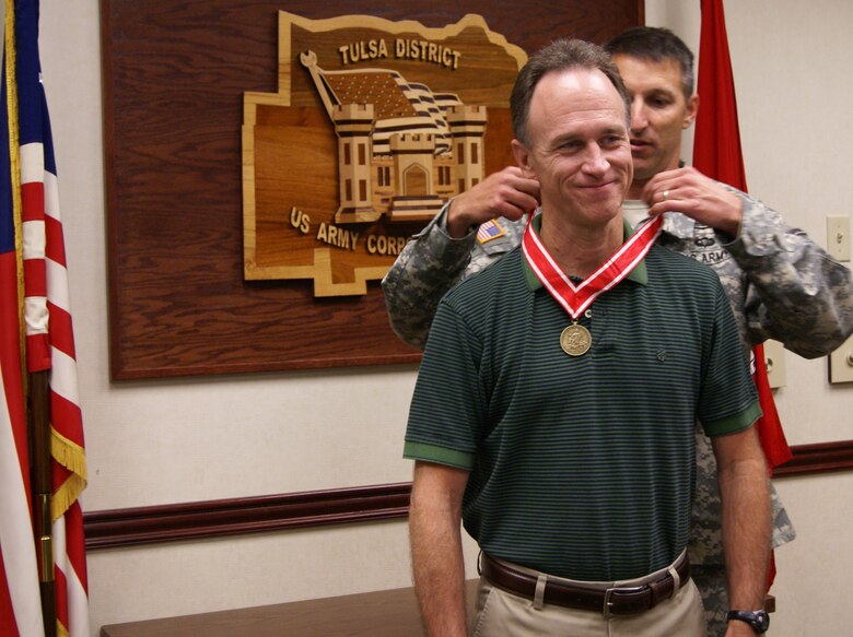The Tulsa District Commander, Col. Richard A. Pratt, presents Louis Vogele, a Civil Works Program Manager, with a bronze de Fleury Medal. The bronze de Fleury Medal is presented to an individual who has rendered significant service or support to an element of the Engineer Regiment.