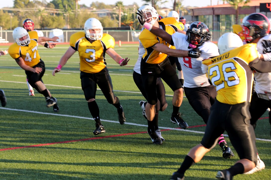 Petty Officer 3rd Class Patrick Williams, Marine Corps Air Station Miramar Falcons’ fullback, stiff arms a 1st Marine Logistics Group Beasts defender during a football game at Paige Fieldhouse aboard Marine Corps Base Camp Pendleton, Calif., Oct. 14. The Falcons defeated the Beasts 26-6 in their last regular season game.